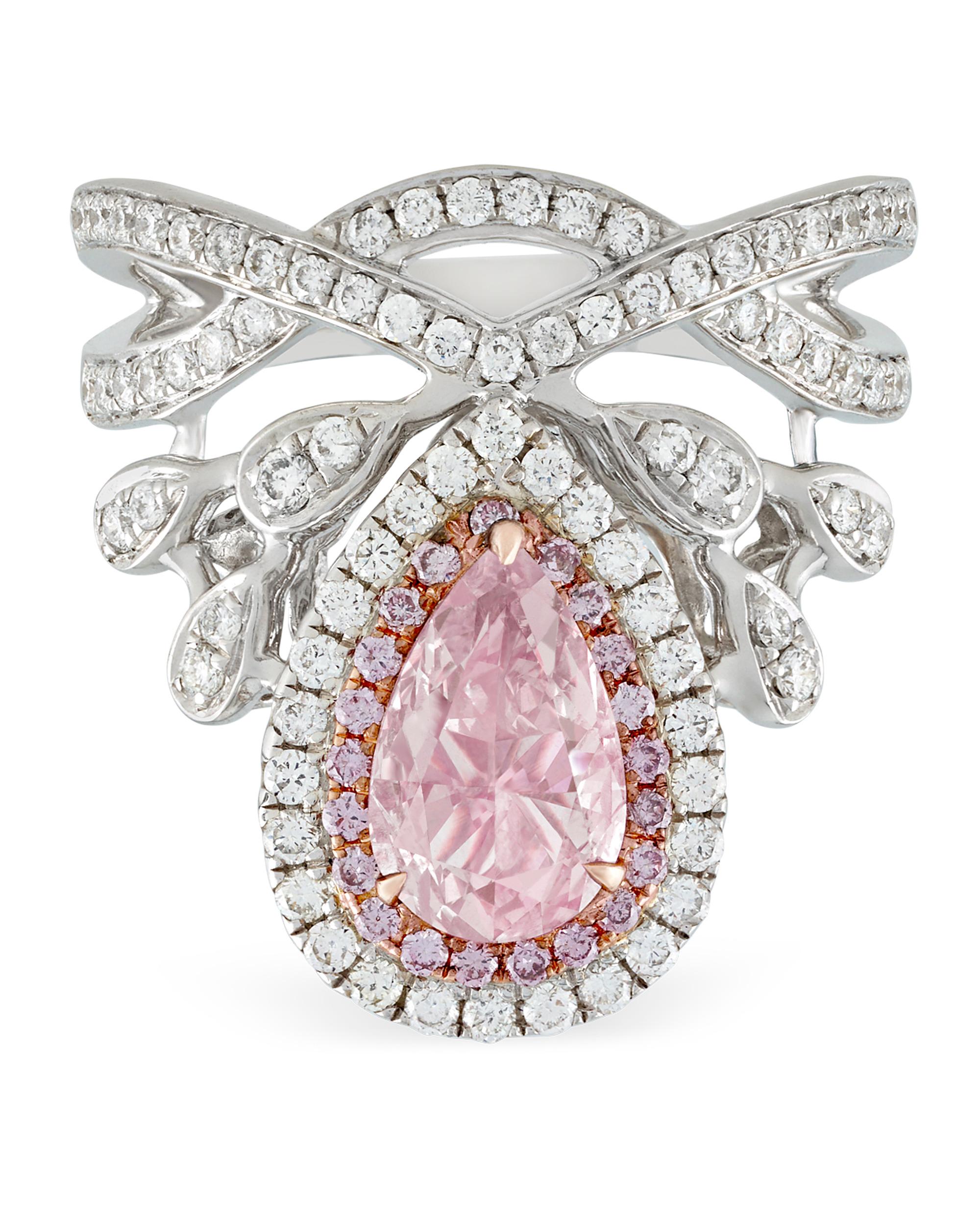 An incredible natural fancy light orangy pink diamond centers this regal, hand-crafted crown ring. The .99-carat pear-shaped rarity is accentuated by white diamonds totaling .62 carats and additional fancy colored diamonds weighing 1.12 carats. The