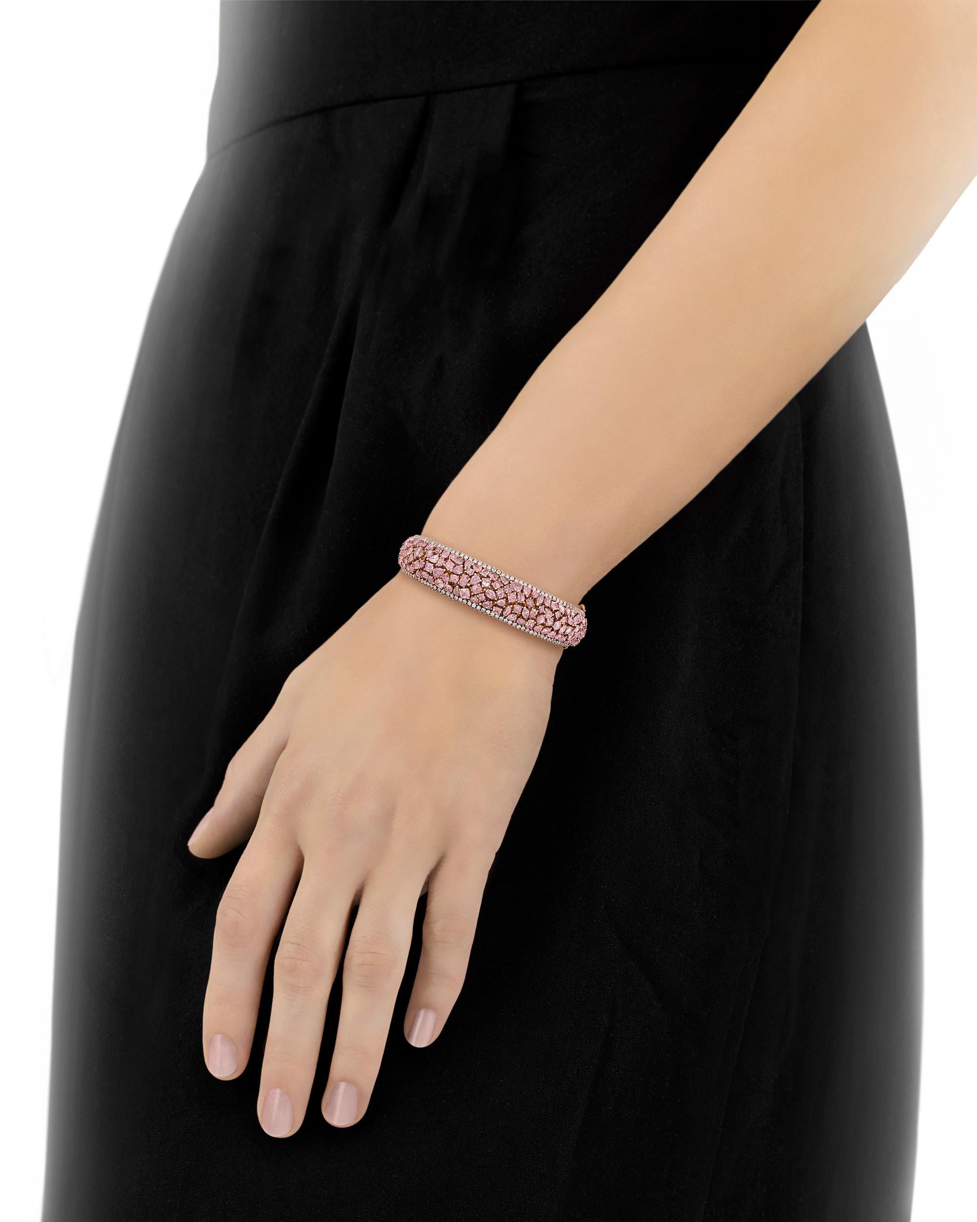 An array of exceptionally rare fancy pink diamonds are set in this exquisite cuff bracelet. Totaling 10.27 total carats, the stones are cut in a range of shapes from marquise and round to pear and cushion, and each is perfectly placed into the