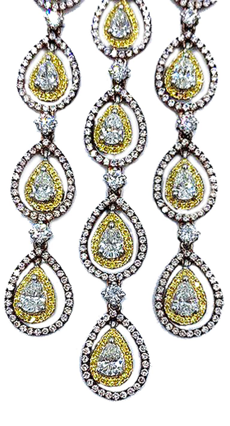 Each beautiful chandelier earring is set with 14 white pear-shaped diamonds.  Each pear is set in white gold bezels. Pave yellow diamonds dangle within a pear-shaped rose gold form, set with pink diamonds. A stunning design, full of sparkle and