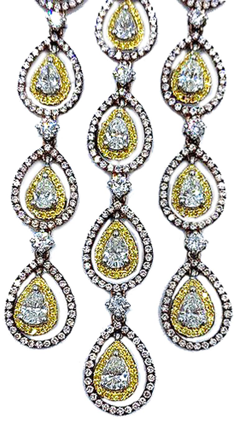 Chaque magnifique boucle d'oreille en forme de lustre est sertie de 14 diamants blancs en forme de poire.  Chaque poire est sertie dans une lunette en or blanc. Des diamants jaunes pavés pendent dans une forme poire en or rose, sertie de diamants