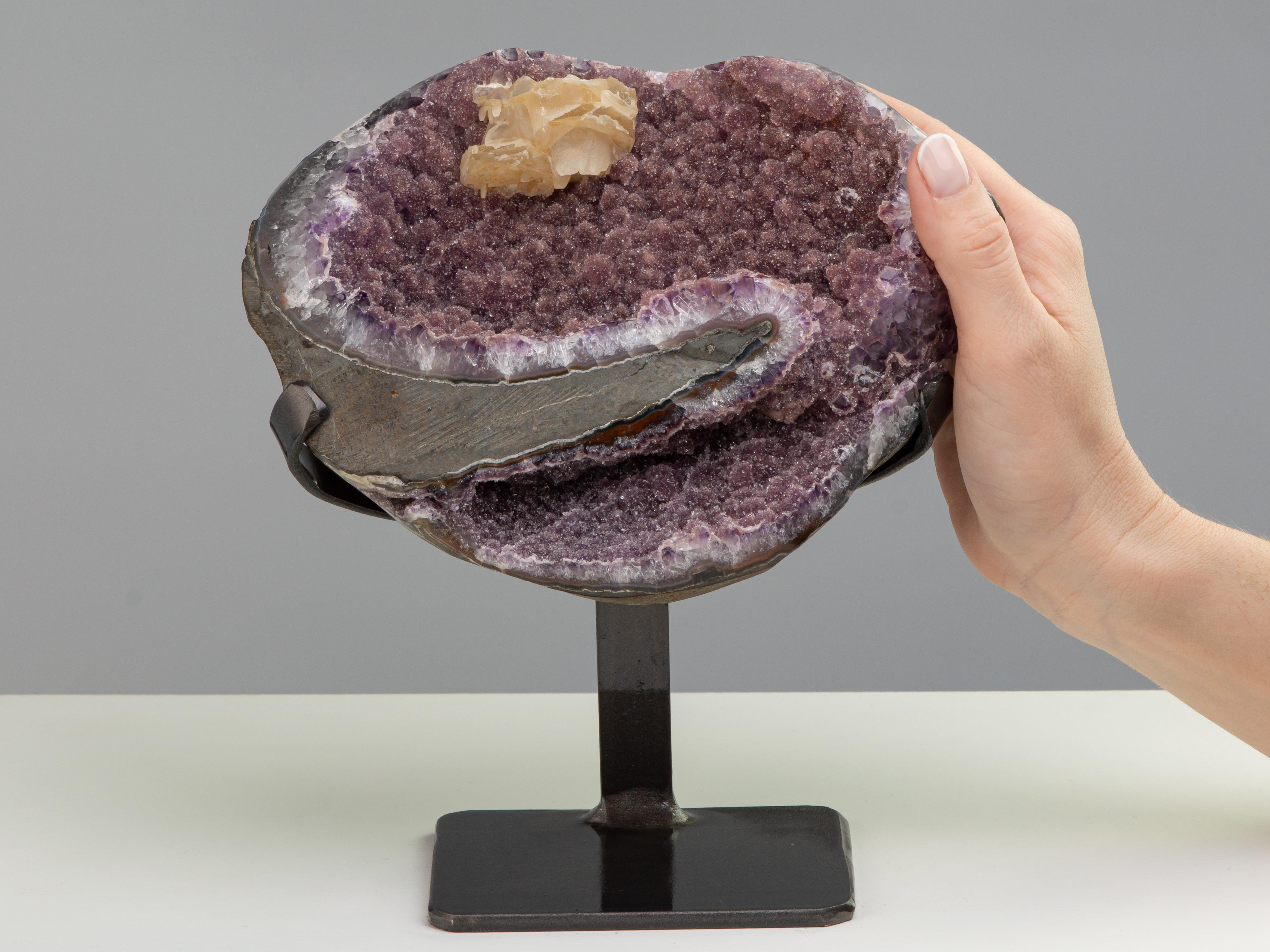 Colours fuse together in this uniquely beautiful piece, presenting the viewer with mixed of pink druze, lilac amethyst and white quartz.

A dynamic mineral sculpture, resembling a heart shape with a calcite formation at its upper section. The