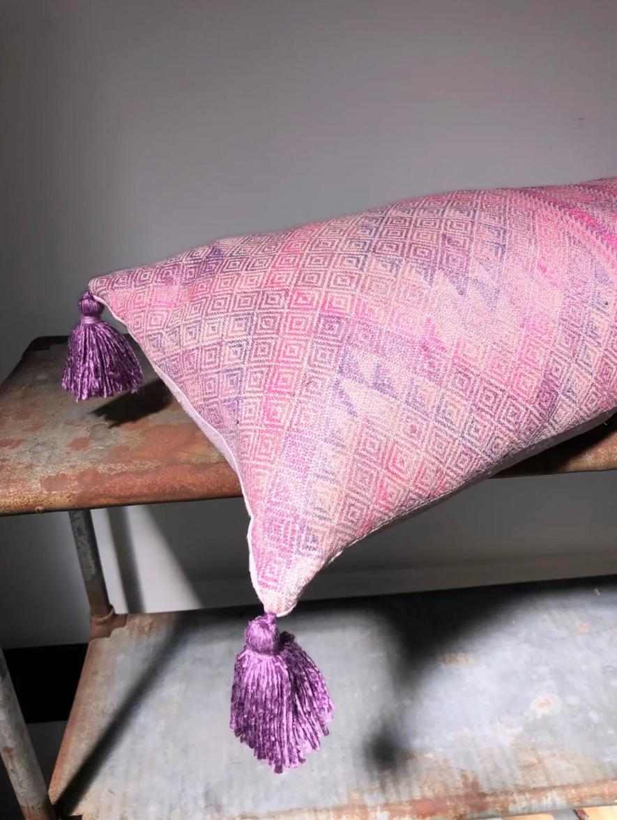 Made from a silk Yao wedding blanket in various shades of pink in a geometric pattern. The cushion is backed with vintage hemp, dyed pale pink and there are handmade tassels at the corners in lavender silk. 