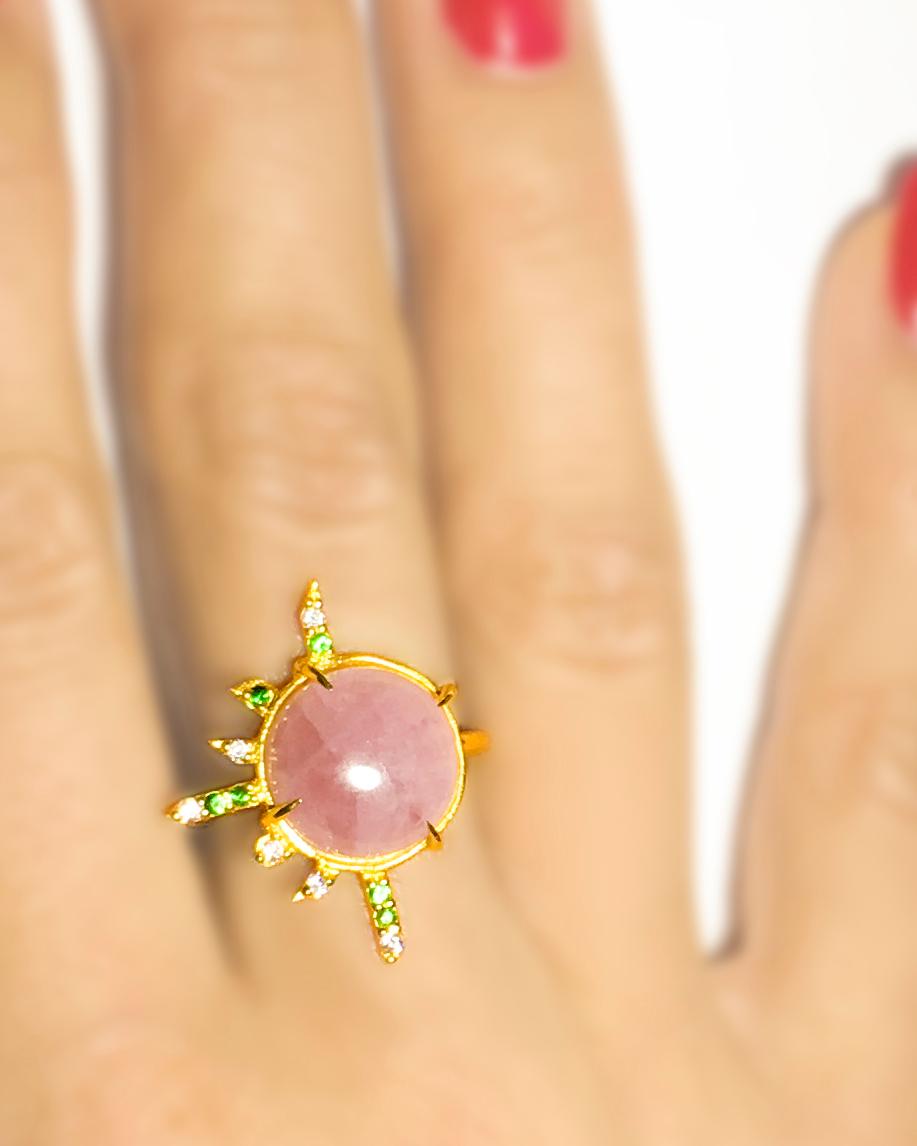 100%  Recycled 14 K Yellow gold
One round cabochon pink opal (12mm/0.472 inches)
Six green tsavorites
Six white diamonds of approximate total 0,085 carats
Approximate jewel size: 25x20mm/0.984×0.787 inches
Yellow gold ring with stones and