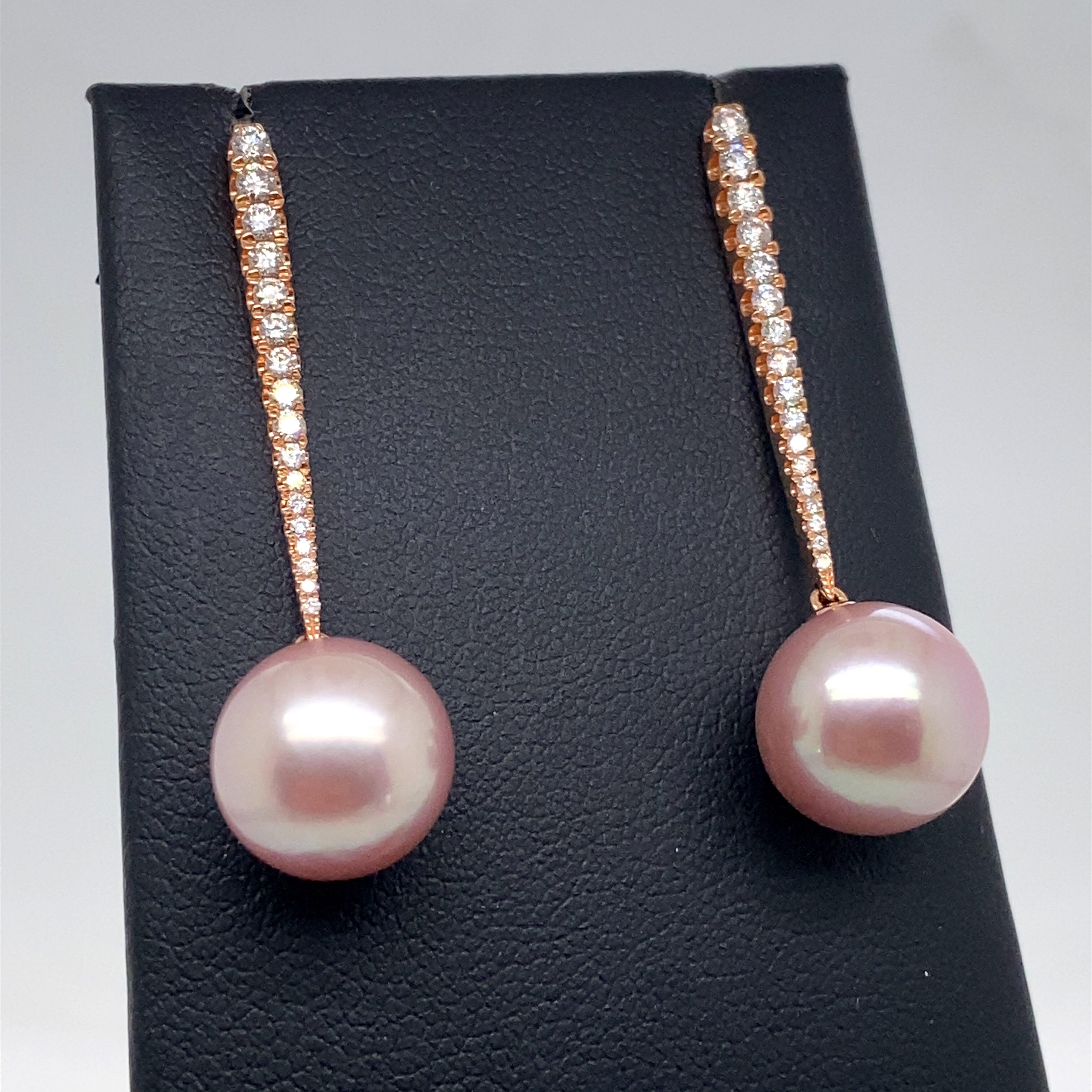 18K Rose gold drop earrings featuring two pink Freshwater pearls measuring 10-11 mm flanked with 34 round brilliants weighing 0.43 carats. 
Color G-H
Clarity SI