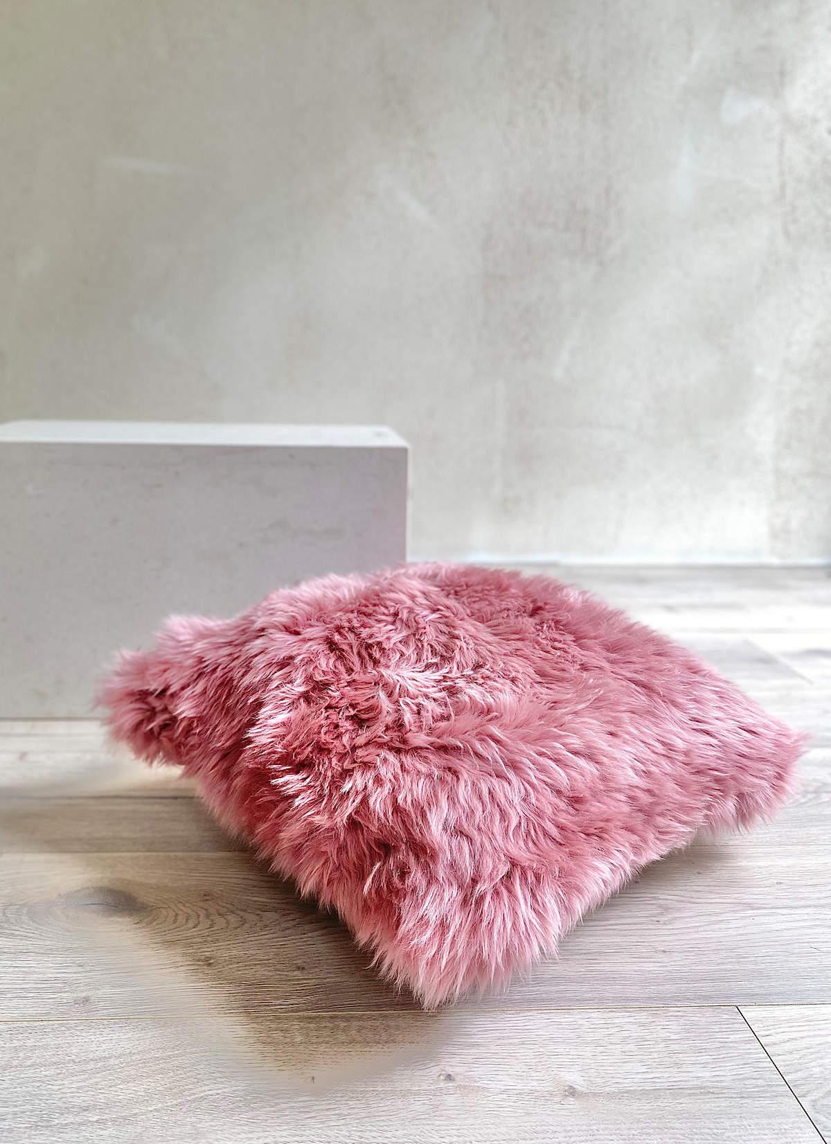 Introduce rich and irresistible tactile elements to your decor with this sumptuous pink fur pillow. Featuring a silky wool pile with superior softness, this collection of hand-crafted fluffy pillows is made from high-quality New Zealand merino