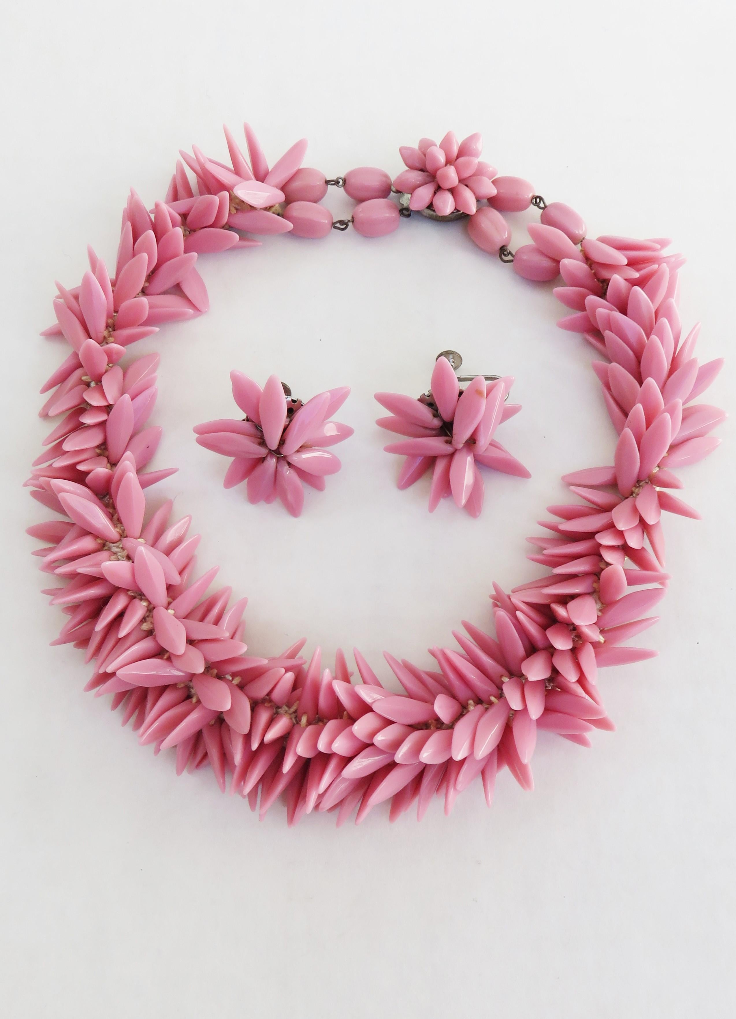 A gorgeous elaborate pink glass beaded choker necklace and screw back earring set.  The oval shaped beads are attached to netting on the underside for comfort and closes at the back with a flower beaded brass backed clasp.  The earrings are screw