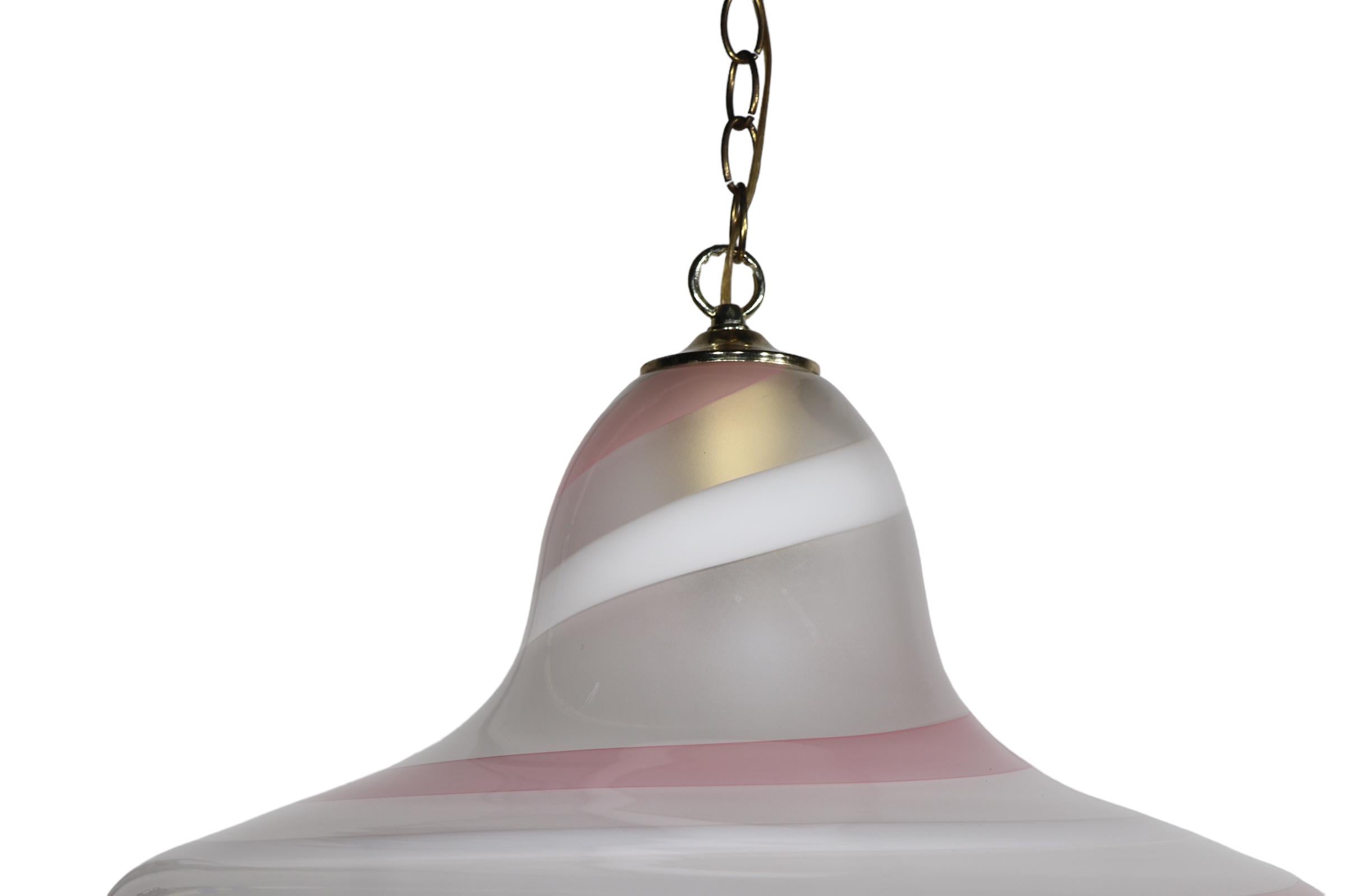 Chic, voguish bell, or hat form art glass chandelier, made in Murano, Italy circa 1970/1980's. The soft pink, cream, gold and soft gray tones executed in an elegant swirl pattern create an elegant and sophisticated look, which is especially