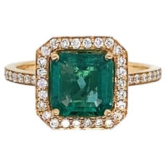 Pink Gold Ring Surmounted by an Emerald Surrounded by Diamonds