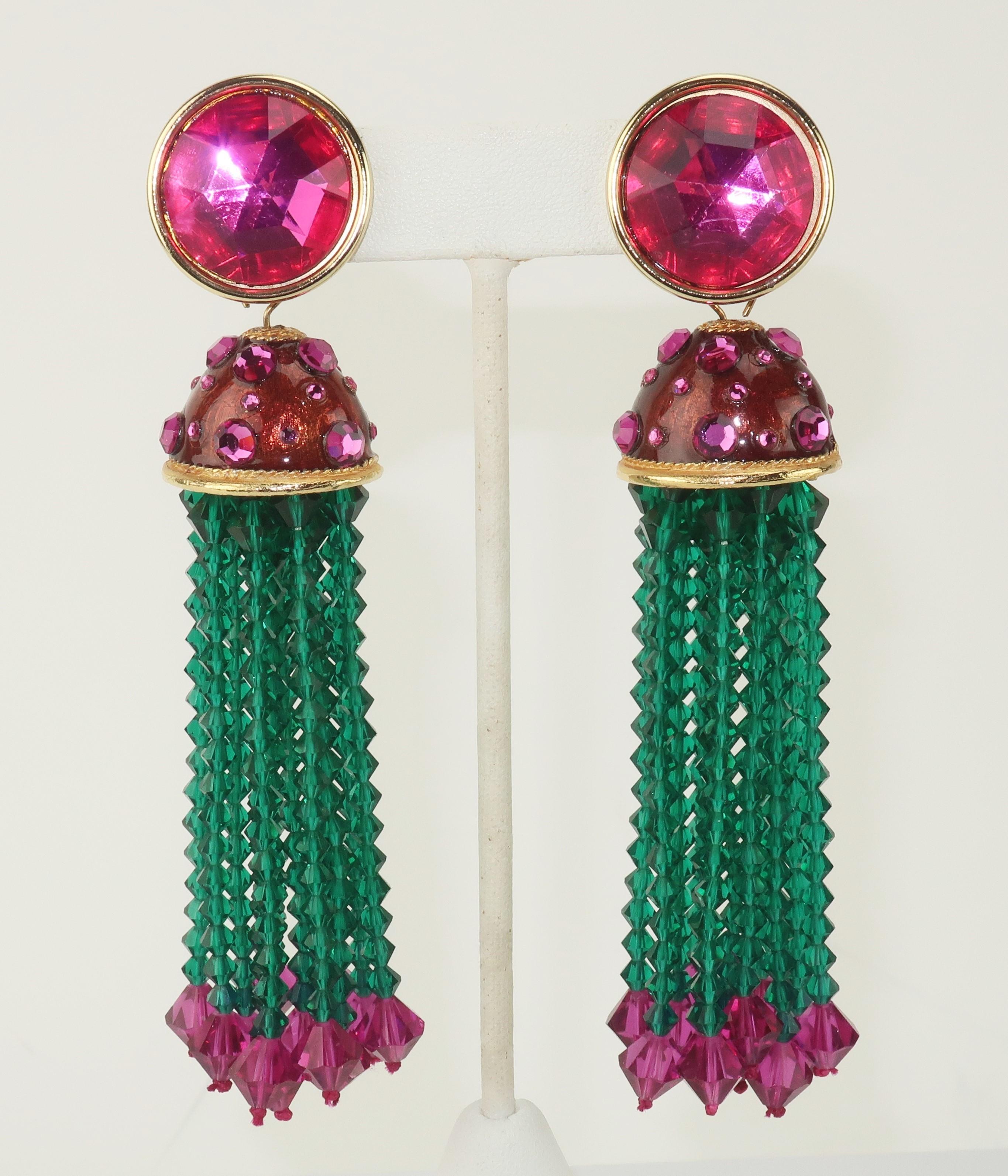 1980’s hot pink and green beaded tassel earrings.  The gold tone clip on bases are accented with faceted hot pink resin stones which suspend a bell shaped enamel dangle embellished with hot pink pave crystals.  They offer a wonderful pop of color in
