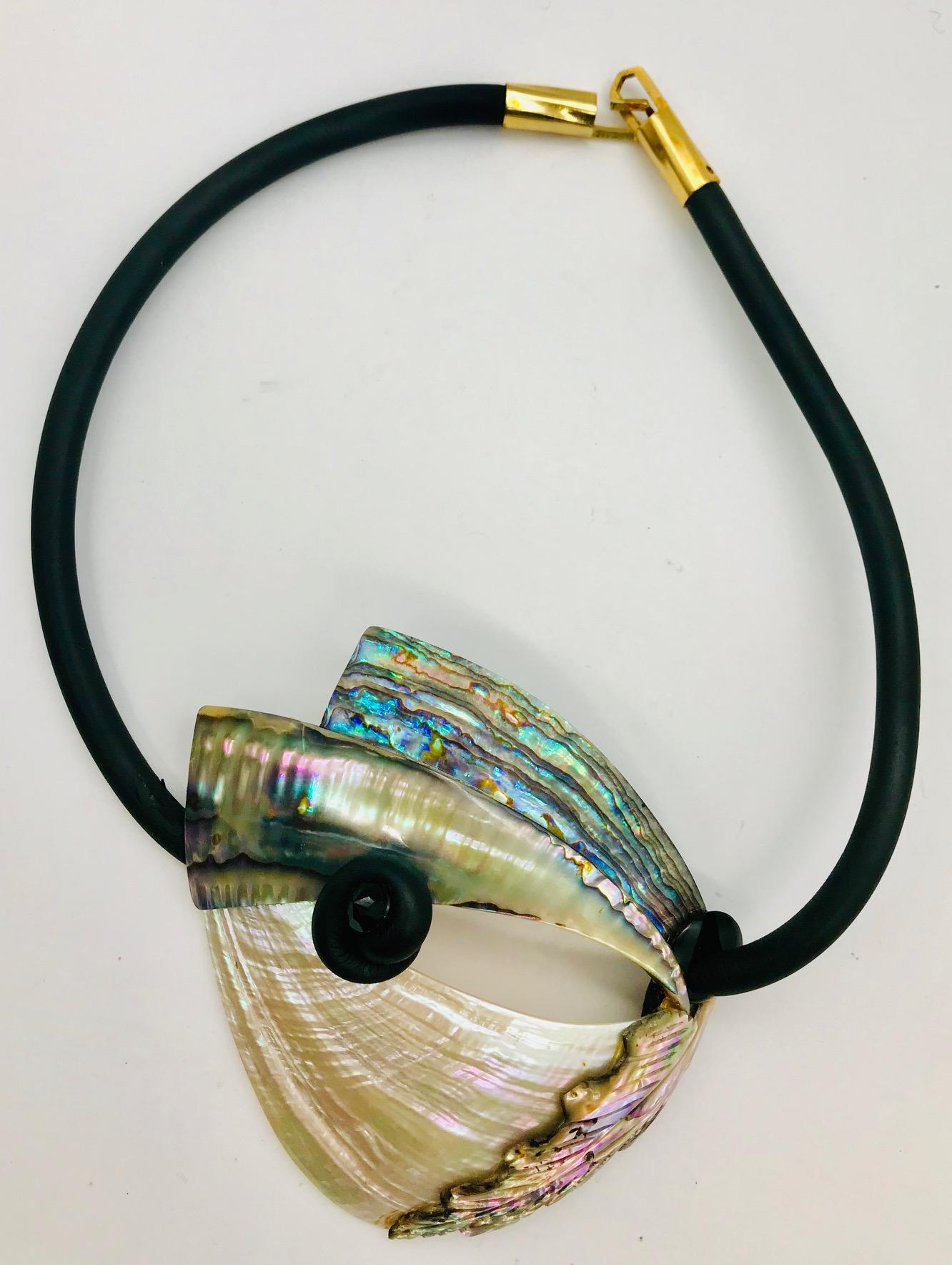 Pink .green, blue Iridescent Abalone Pendant/Necklace on rubber tube with gold plated  custom designed clasp. It is an unusual creation because it has Haliotis / Abalone sourced from 4  in the world oceans, From left to right Tahiti, Thailand,