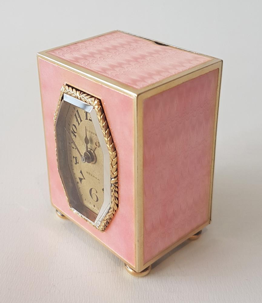 A fine and unusual miniature carriage or boudoire clock in silver gilt and decorated with pink guilloche enamel on four sides, with fine engine turned design to the back, by Eterna. The enamel is perfect with no chips or damage, and the clock