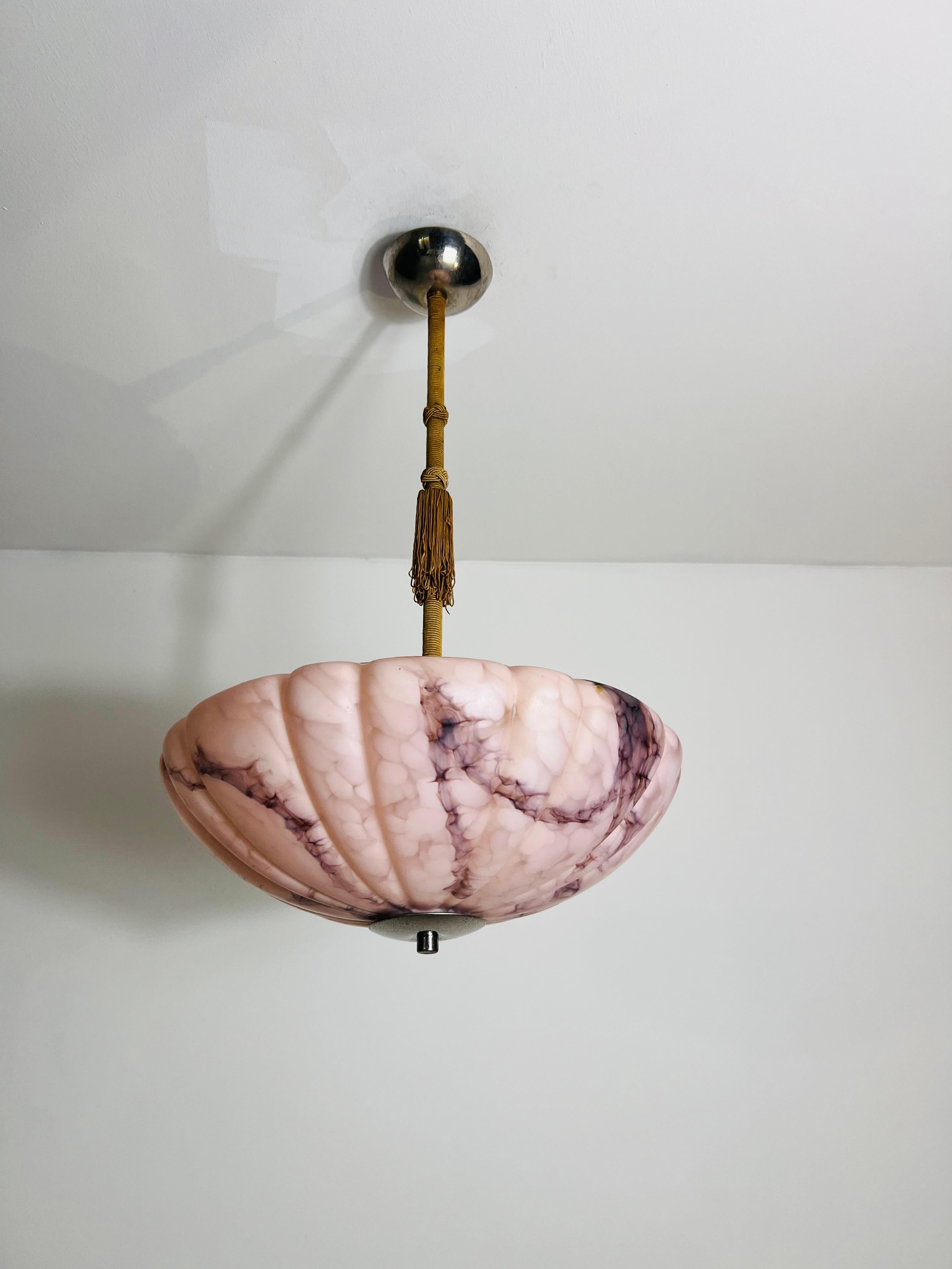 Schöne rosa Alabaster-Hängeleuchte aus den 1930er Jahren, hergestellt in Deutschland. Das weiche, diffuse Licht, das durch den geäderten Alabaster fällt, schafft eine warme und einladende Atmosphäre und macht sie zu einem perfekten Mittelpunkt für