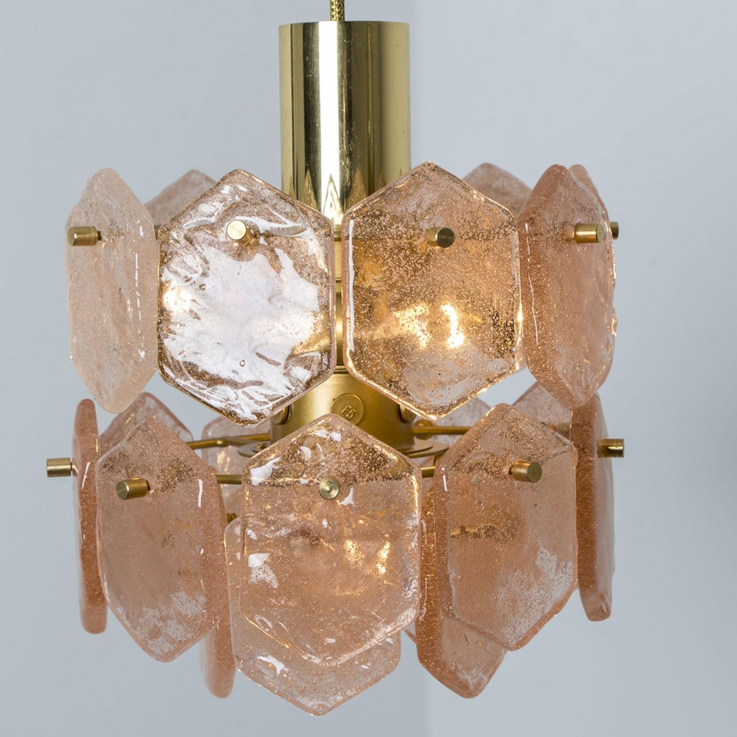 La lámpara de cristal de hielo Kalmar Franken, fabricada en Austria en la década de 1960, es realmente cautivadora por sus singulares formas de cristal. Esta lámpara de araña de cuatro niveles presenta piezas hexagonales de cristal rosa hielo, que