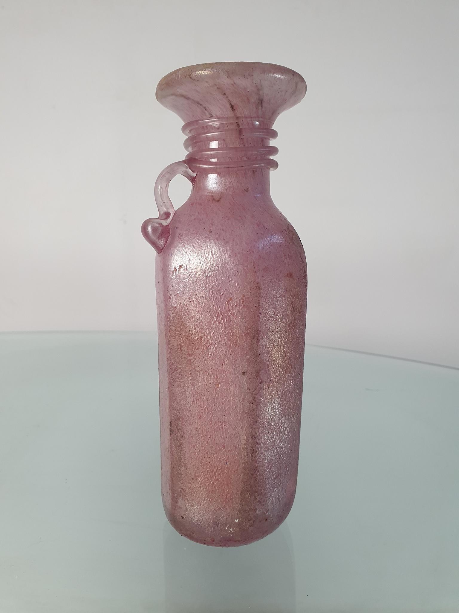 Eine schillernde rosa Vase aus rosa/violettfarbenem Murano-Glas, die dem berühmten Glaskünstler Archimede Seguso zugeschrieben wird

Archimede Seguso war ein italienischer Glashersteller, der für seine komplizierten Glasvasen, Halsketten und