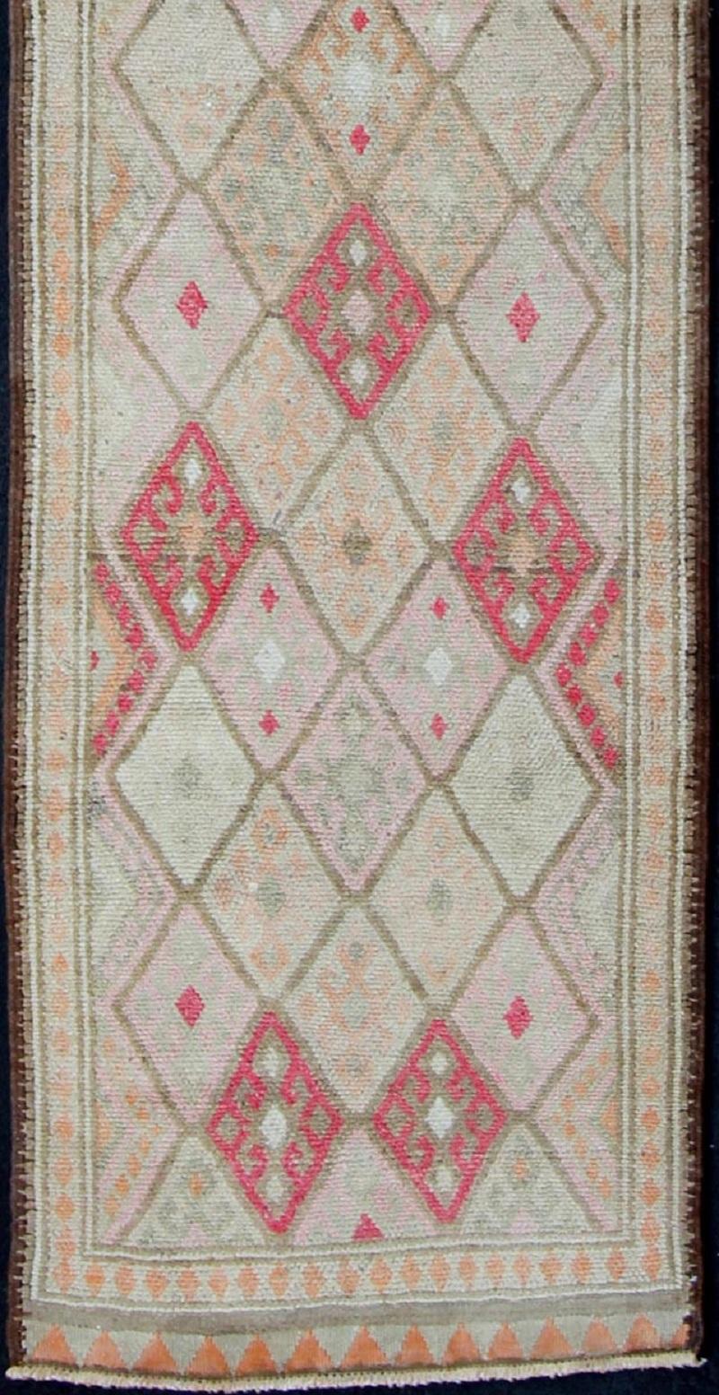 Vintage runner from Turkey with all-over design of geometric diamonds with Kurdish in pink, ivory, taupe, green/gray and soft orange tones, rug en-165324, country of origin / type: Turkey / Oushak, circa 1950.

This beautiful vintage Turkish