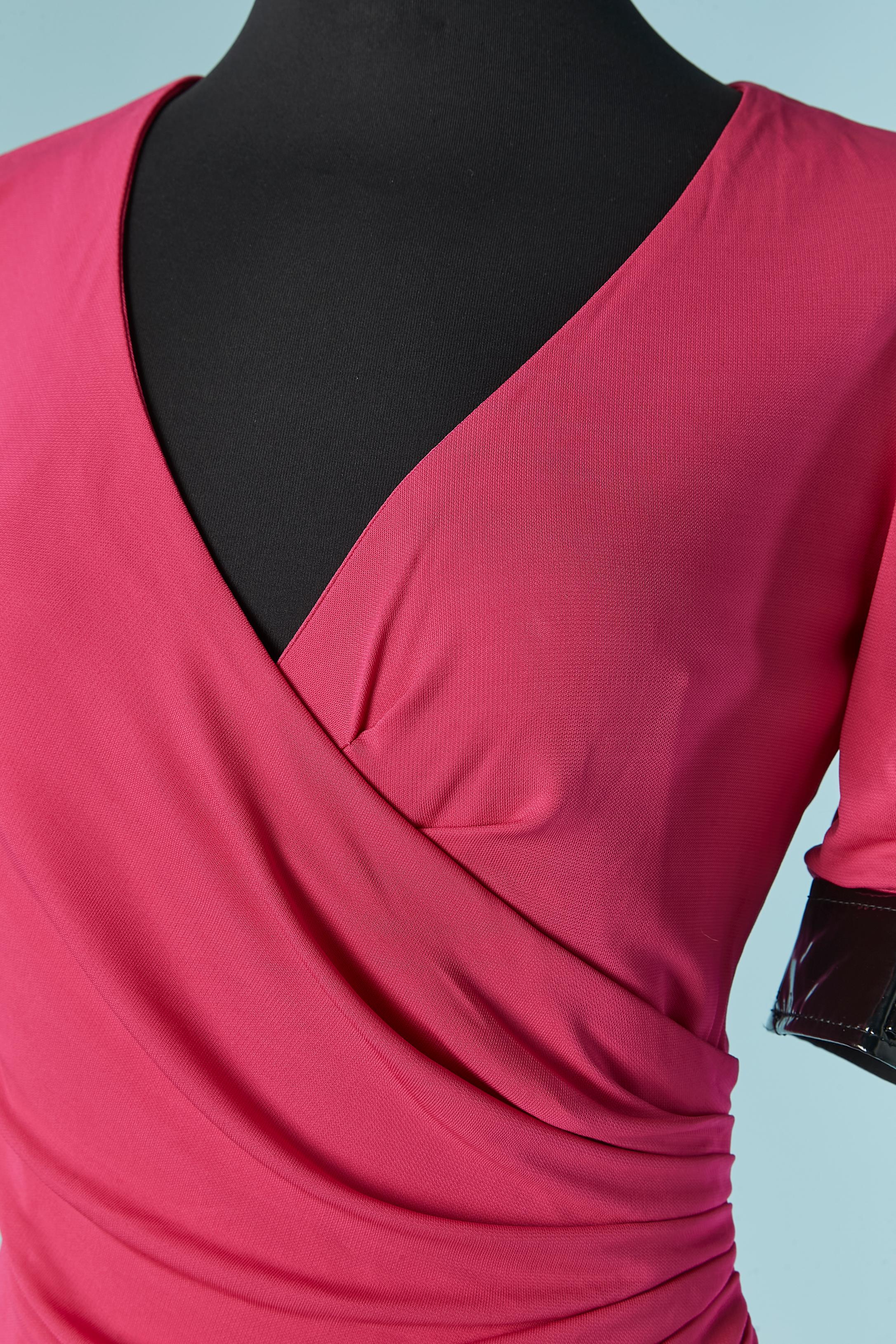 Pink jersey wrapped dress with black vinyl details . Draped and wrapped on the front. Invisible zip on the side . Vinyl edge on the sleeve with buckle. 
SIZE 38 (Fr) M 