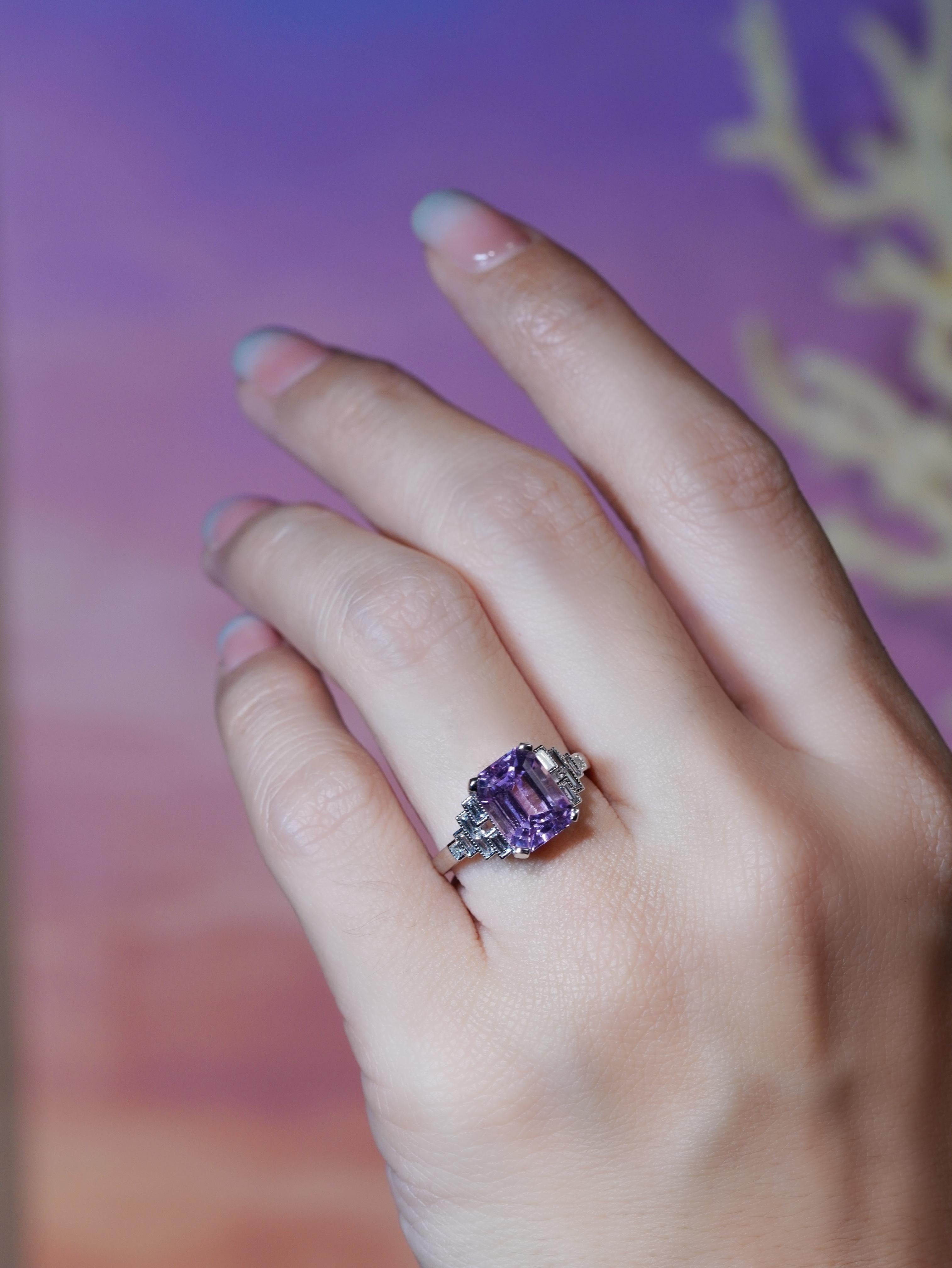 Élégante et romantique, cette bague de fiançailles de style Art déco présente en son centre une étonnante baguette de kunzite rose. Sertie dans une lunette géométrique élégante, la pièce maîtresse rayonne d'un charme doux et féminin. Les épaules