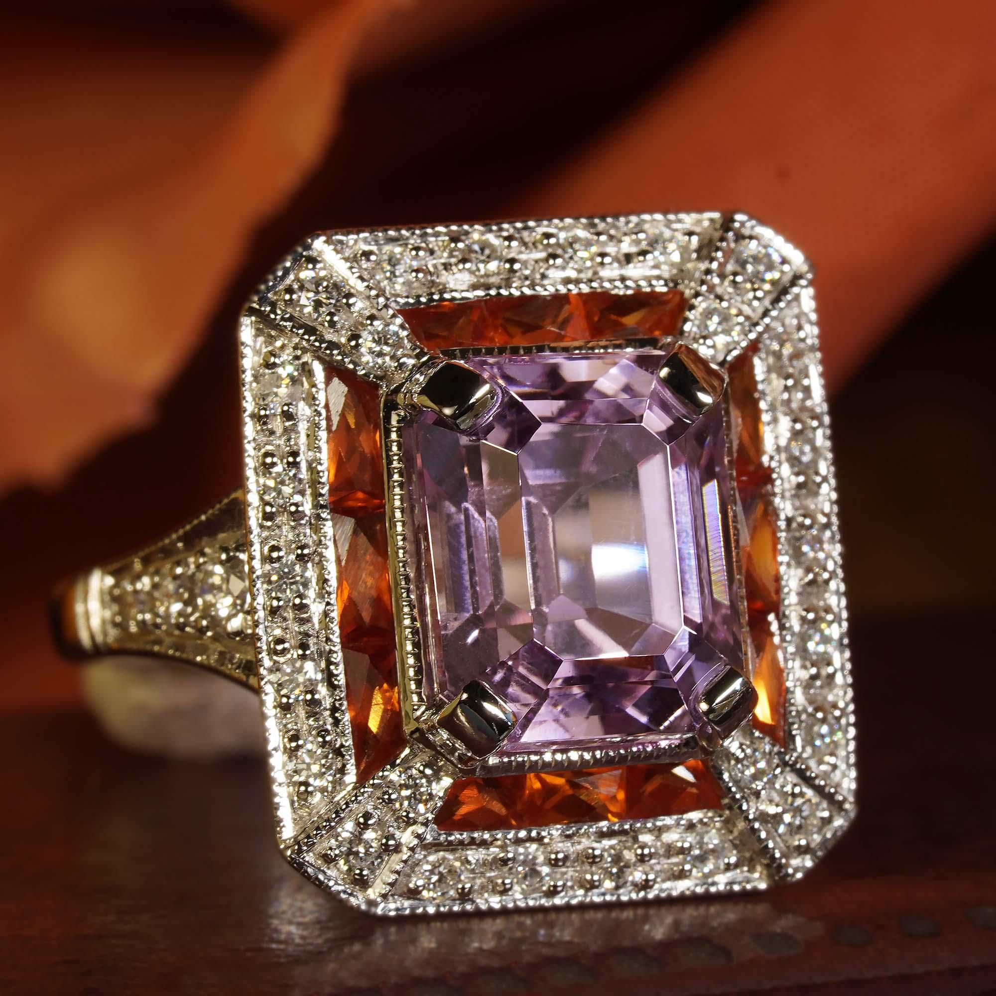 Make a powerful statement in pink. This Art Deco inspired 14k white gold ring features a perfect sparkly emerald cut pink kunzite set into an octagon shape setting. The center stone is framed in French cut orange sapphires, finished with outer