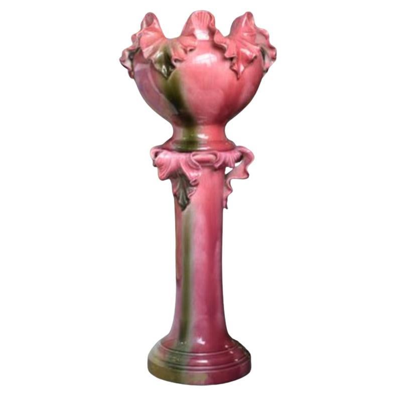 Macetero de cerámica mayólica rosa sobre columna firmado por Jerôme Massier, años 30