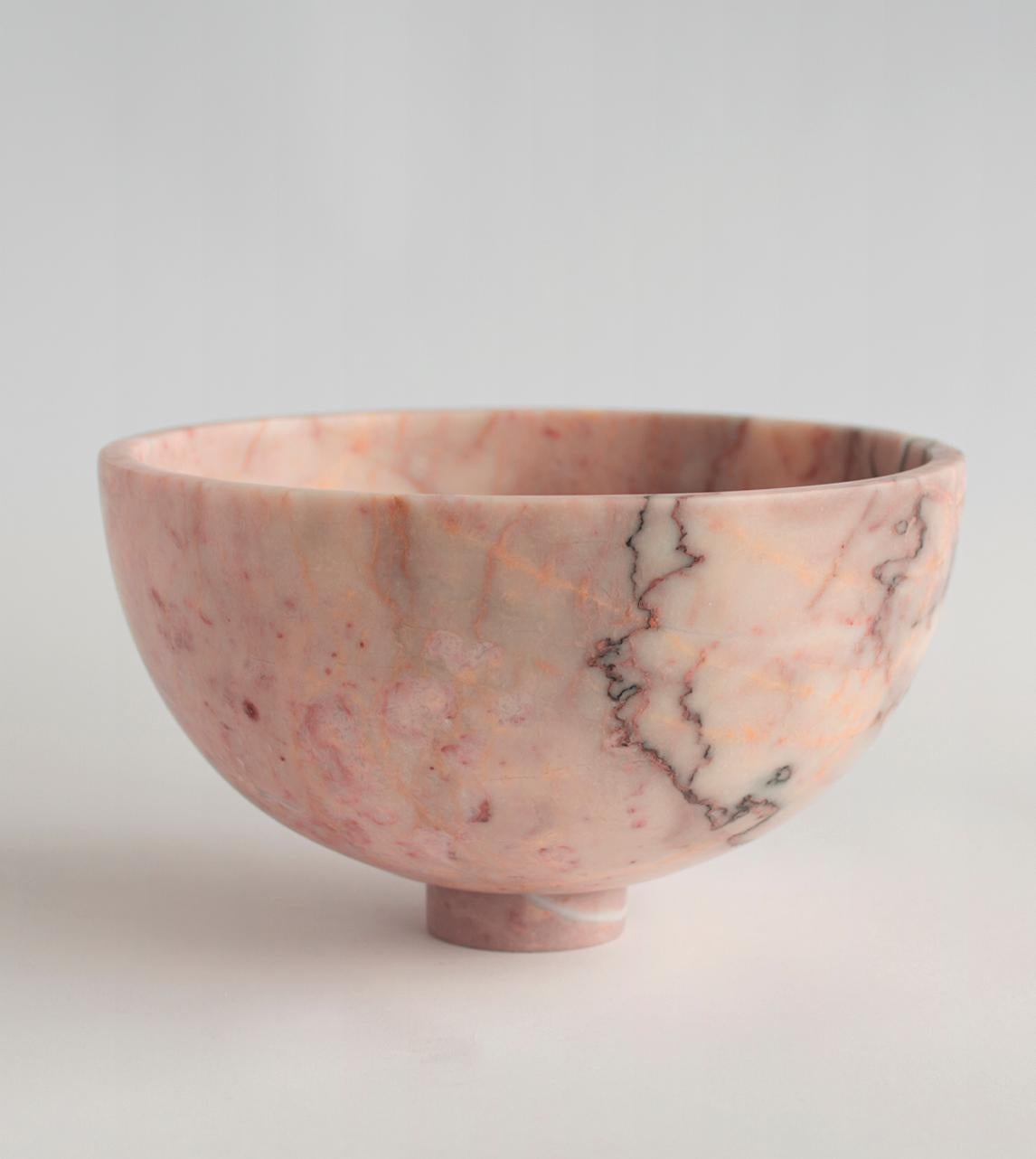 A substantial pink marble bowl with unique white veining rests atop a mini pedestal for a grand presentation of fruits and vegetables. It is truly an eyecatcher in your dining room. 

There may be natural variations that are not product flaws,