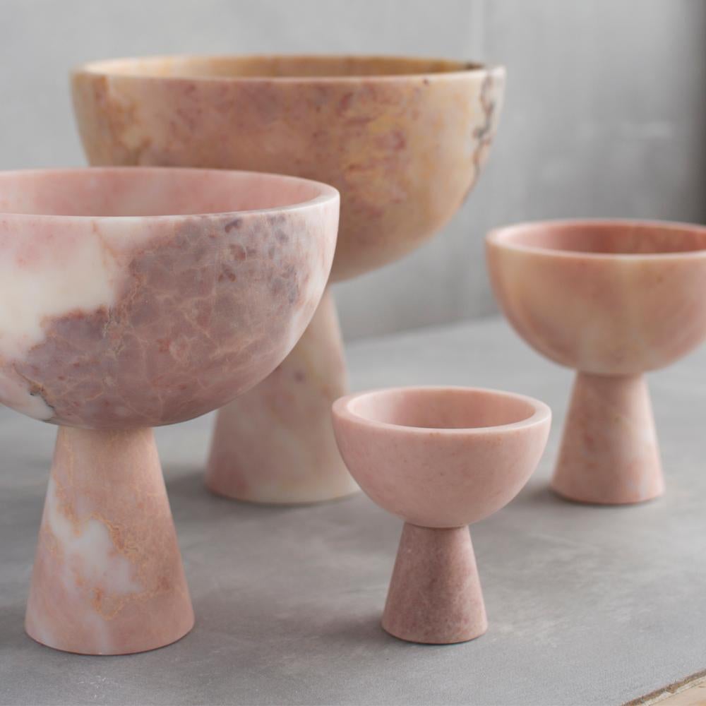 Un grand bol en marbre rose avec des veines blanches uniques repose sur un piédestal pour une présentation grandiose de fruits et de légumes. 

L'exposition à l'acide des agrumes peut tacher le marbre. En raison des propriétés naturelles du marbre,