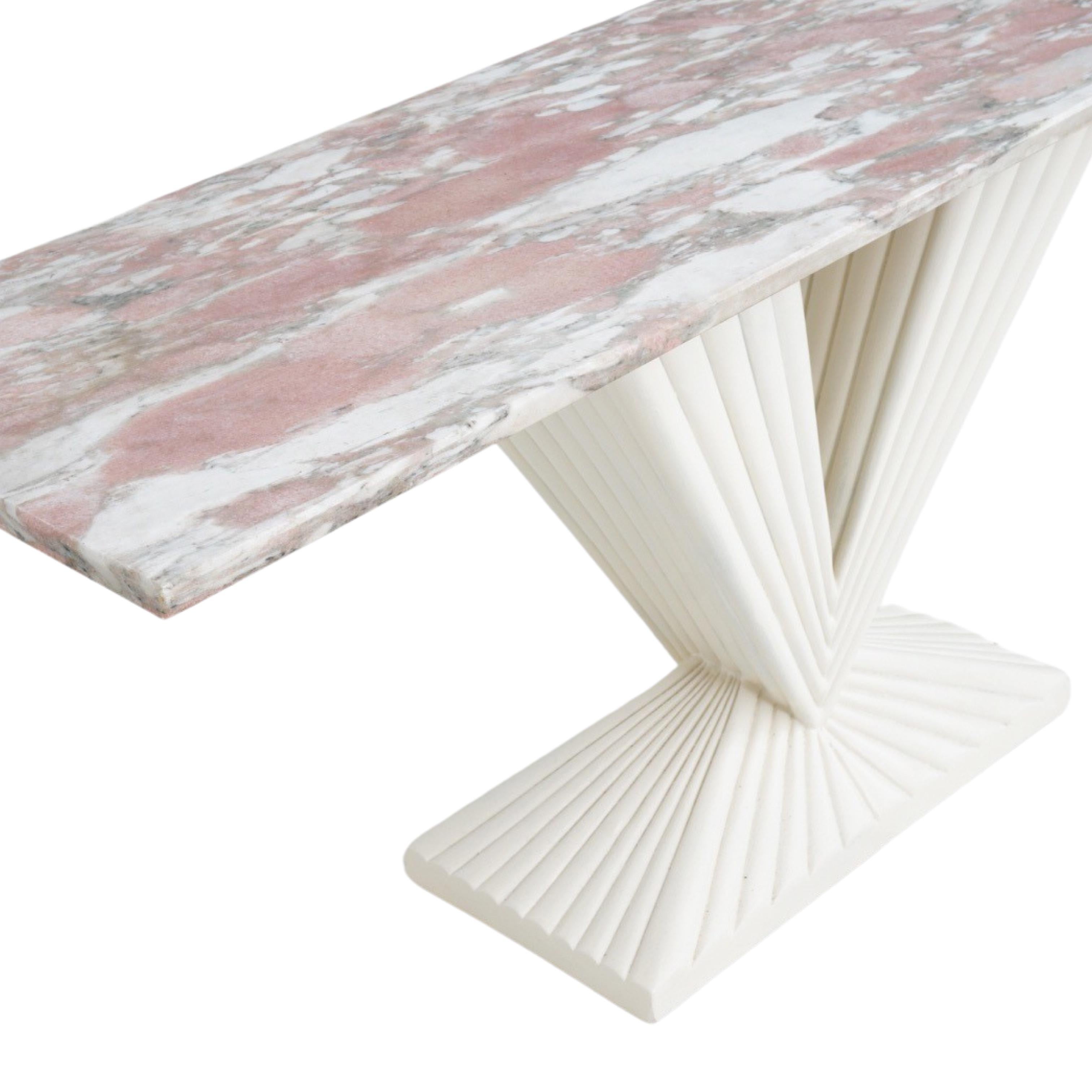 Avec sa teinte bubblegum et son plateau en marbre aux veines complexes, cette table console trouve un équilibre délicat entre flamboyance et élégance. Le marbre veiné, avec un doux mélange de couleurs et de veines fluides, crée un sentiment de