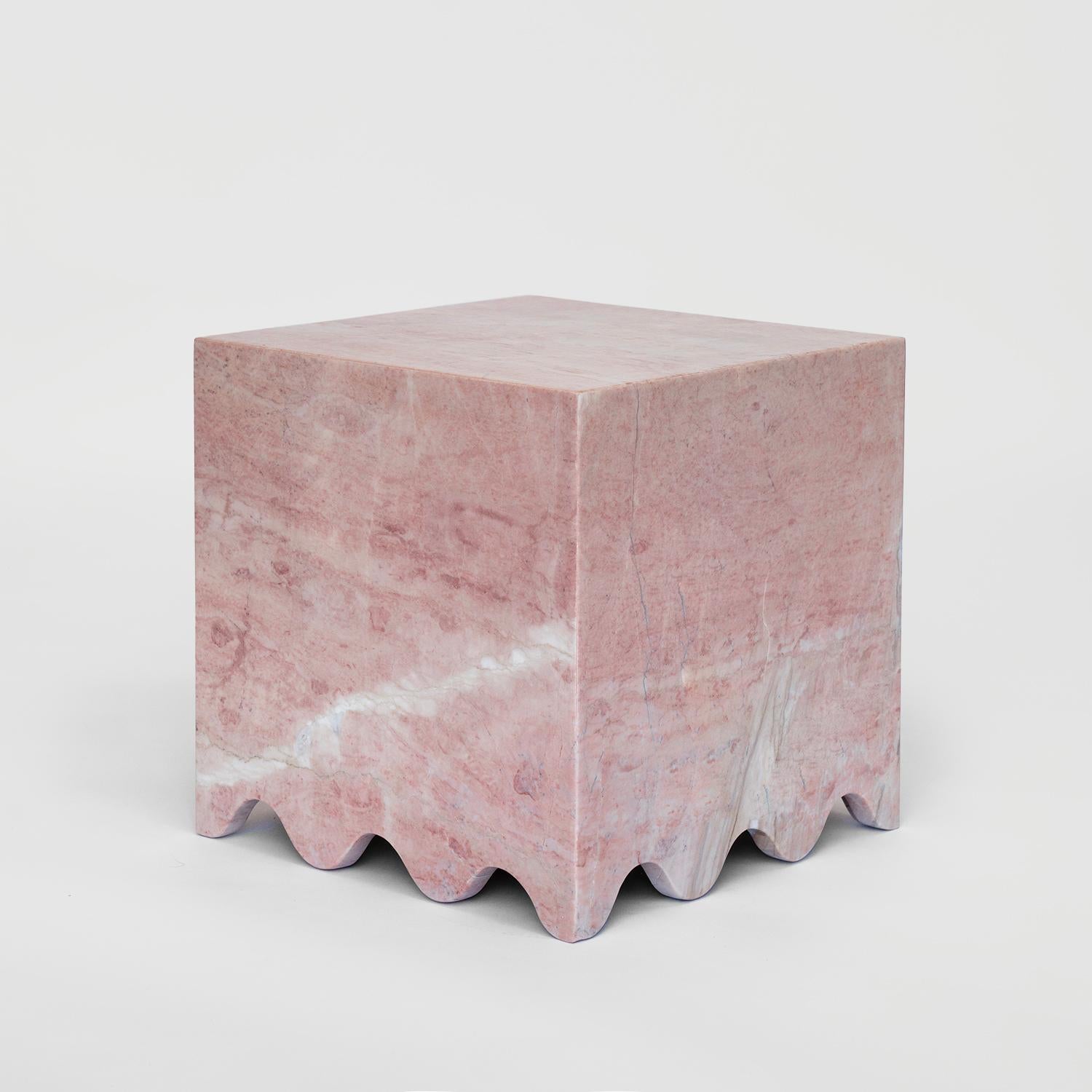 FLOW is a modern pink marble side table with a clean shape and a wave detail at the bottom. The simple cube form is combined with a flowing base, giving the table a light and playful look.

The table is made from solid natural stone plates and
