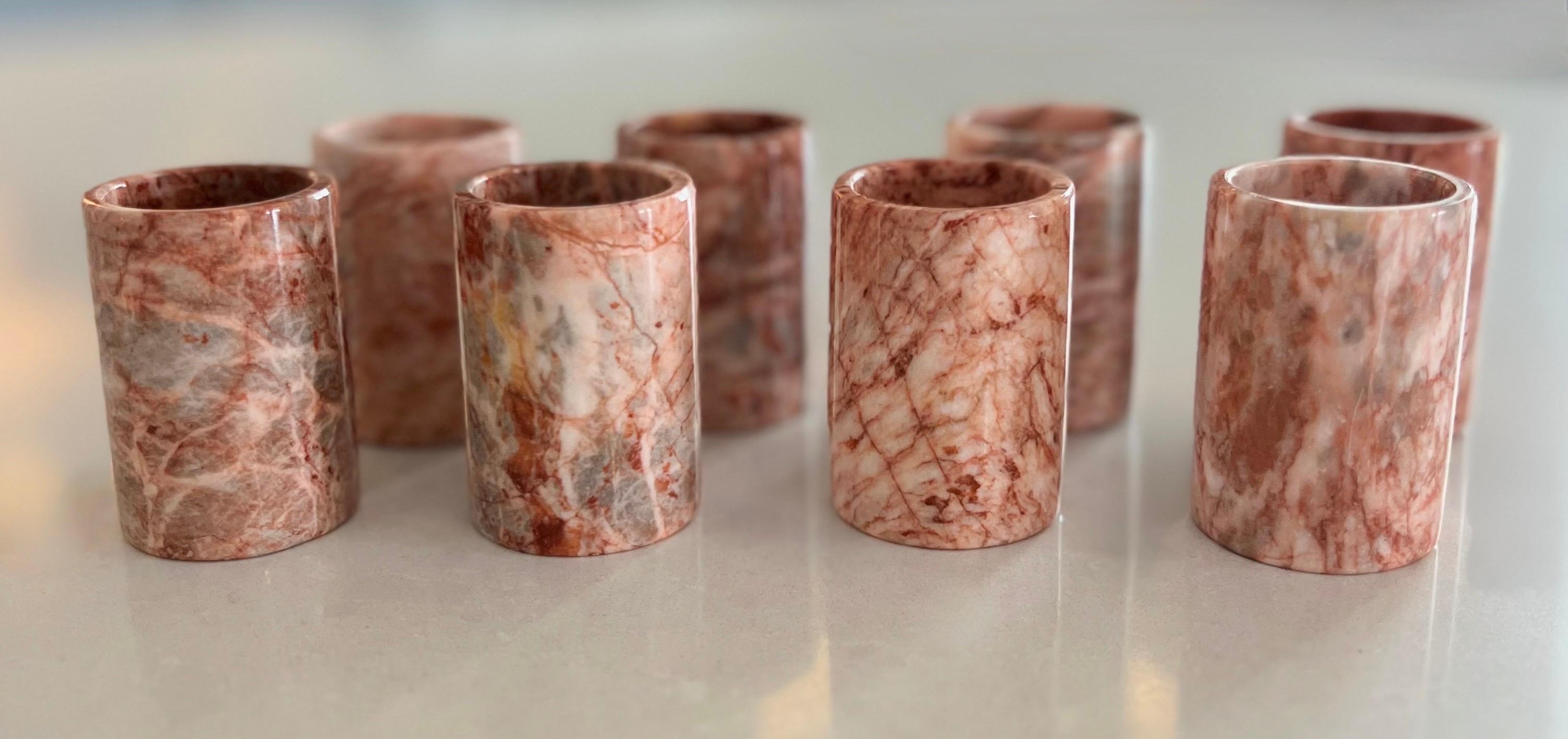 Up your bar cart game with this set of eight handmade pink marble shot glasses.  Each glass features beautiful shades of pink with coral and grey veining.  Each glass measures 2.5-inch height by 1.5-inch diameter.

These are natural stone glasses