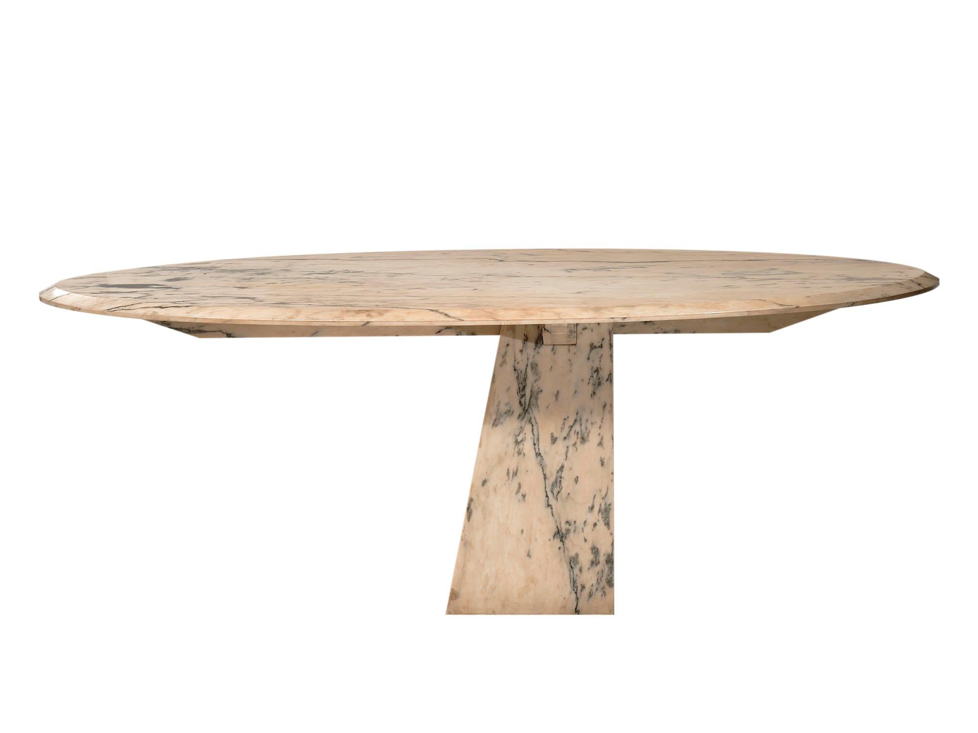 Marble dining table from Italy made of Diana Rosa Carrara Marble. The top sits on a pyramidal base in a cantilevered dynamic.