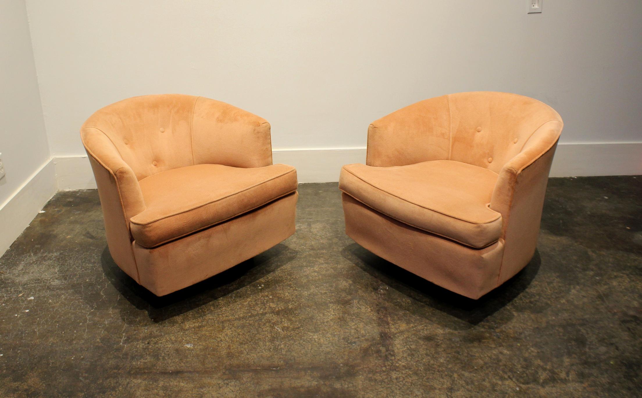 Pair of vintage Baughman-style swivel club chairs in salmon pink with circular walnut wood bases. Chairs are from 1970s-1980s, rock and swivel and are sturdy and function smoothly. Some minor wear to upholstery. (see pictures).