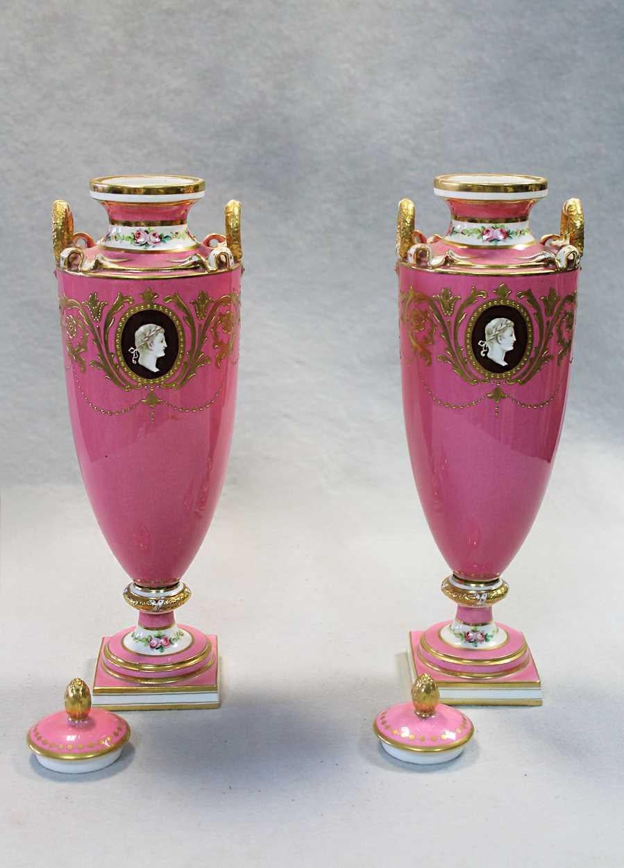 Pink Minton Medallion vases ground bodies reserved with two oval panels painted with the profiles of classical figures, supported by scrolling acanthus in 24-karat gold gilt with hand painted roses and raised gold jewels with ribbon tops and