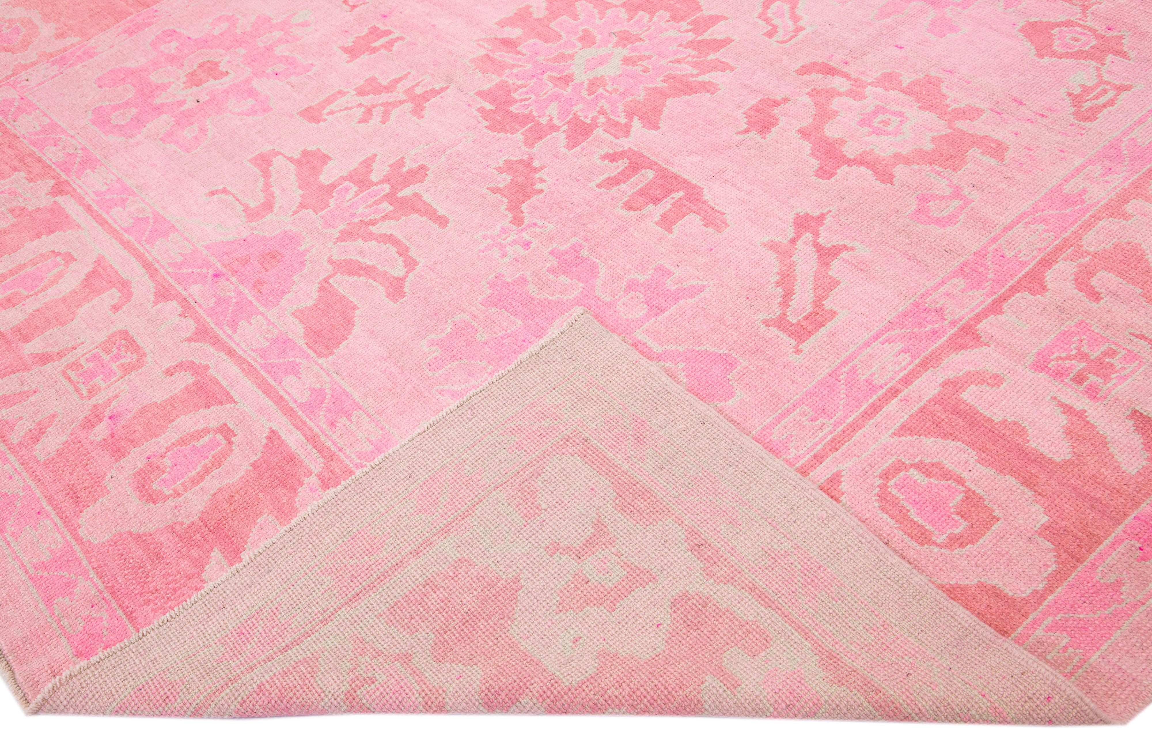 Beautiful modern Turkish Oushak hand-knotted wool rug with a pink color field in a gorgeous all-over floral design.

This rug measures: 9'5