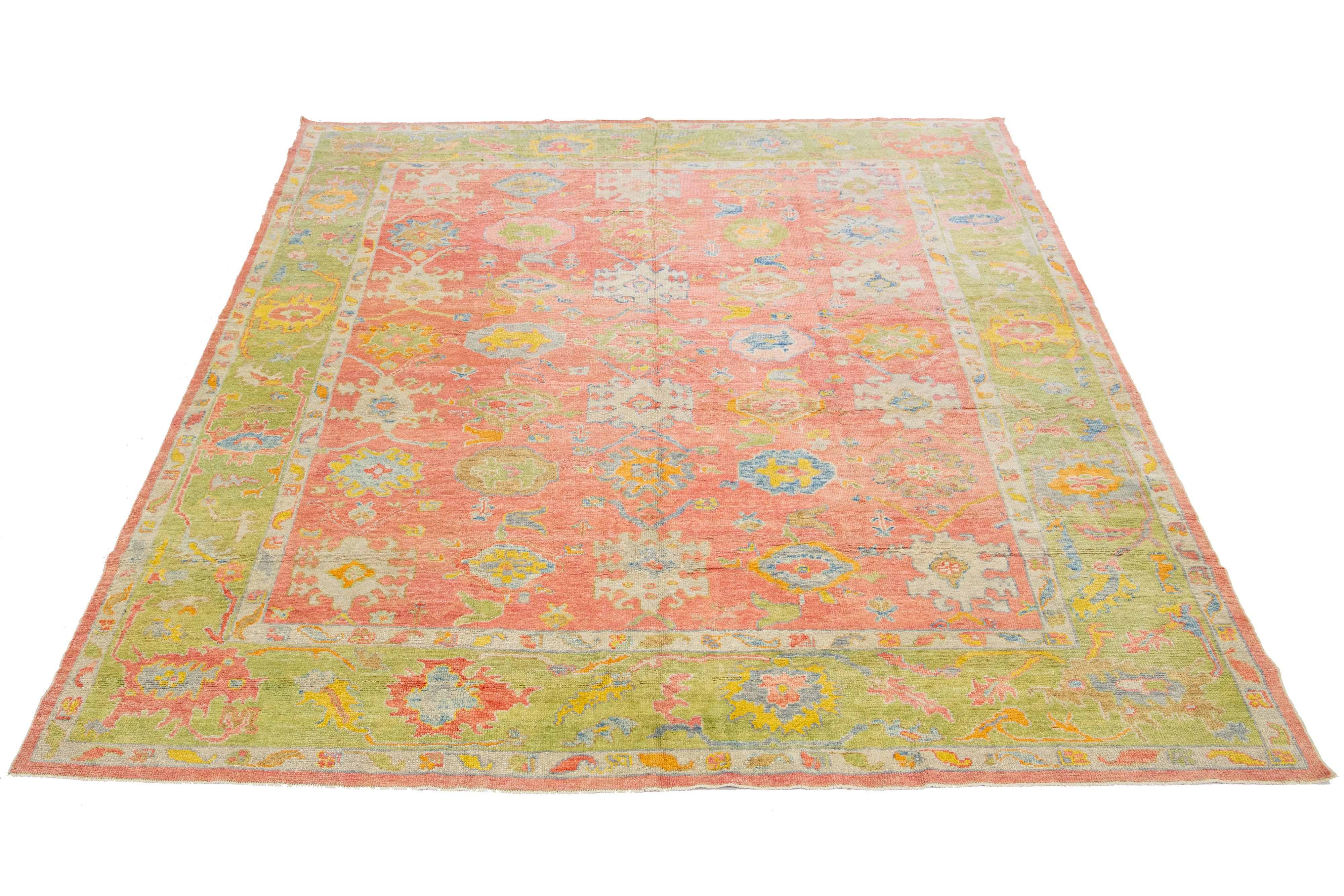 Beautiful modern Oushak hand knotted wool rug with a pink field. This Oushak rug has a green frame and multi-color accents all-over a gorgeous geometric floral design.

This rug measures 10'8