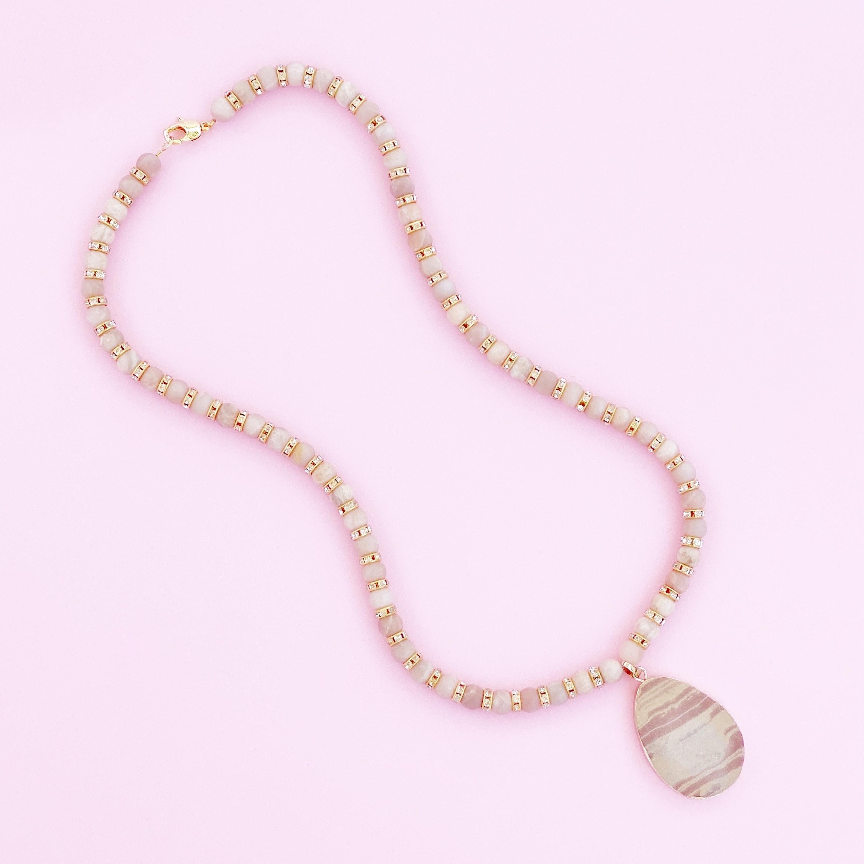 8mm smooth matte Pink Moonstone gemstones flanked by crystal rhinestones and gold-plated accents with a red striped druzy slice charm with gold electroplated edges.  

24