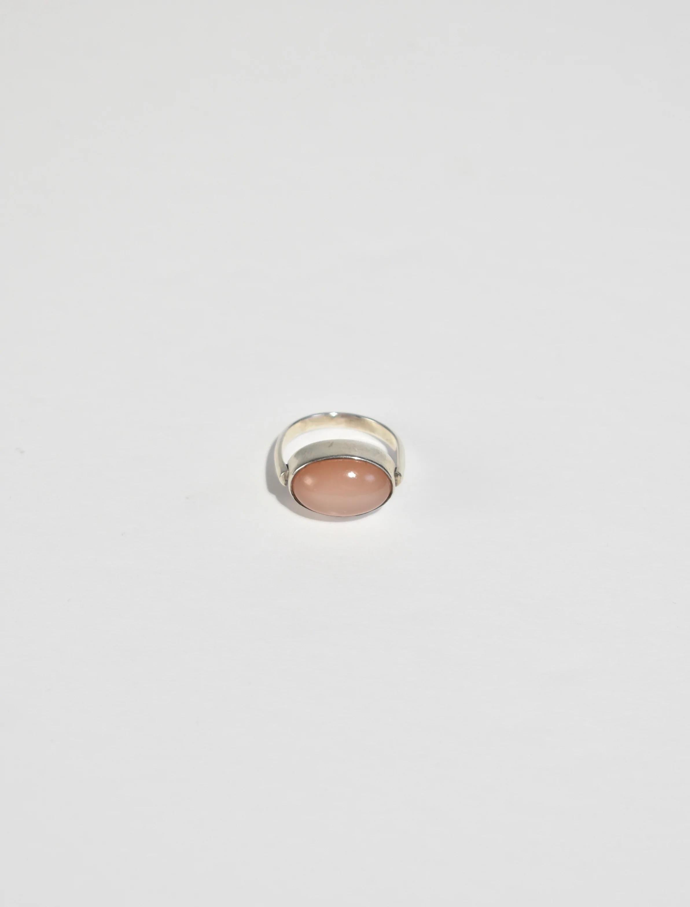 Beautiful vintage sterling ring with an oval pink moonstone cabochon.

Material: Sterling silver, moonstone.