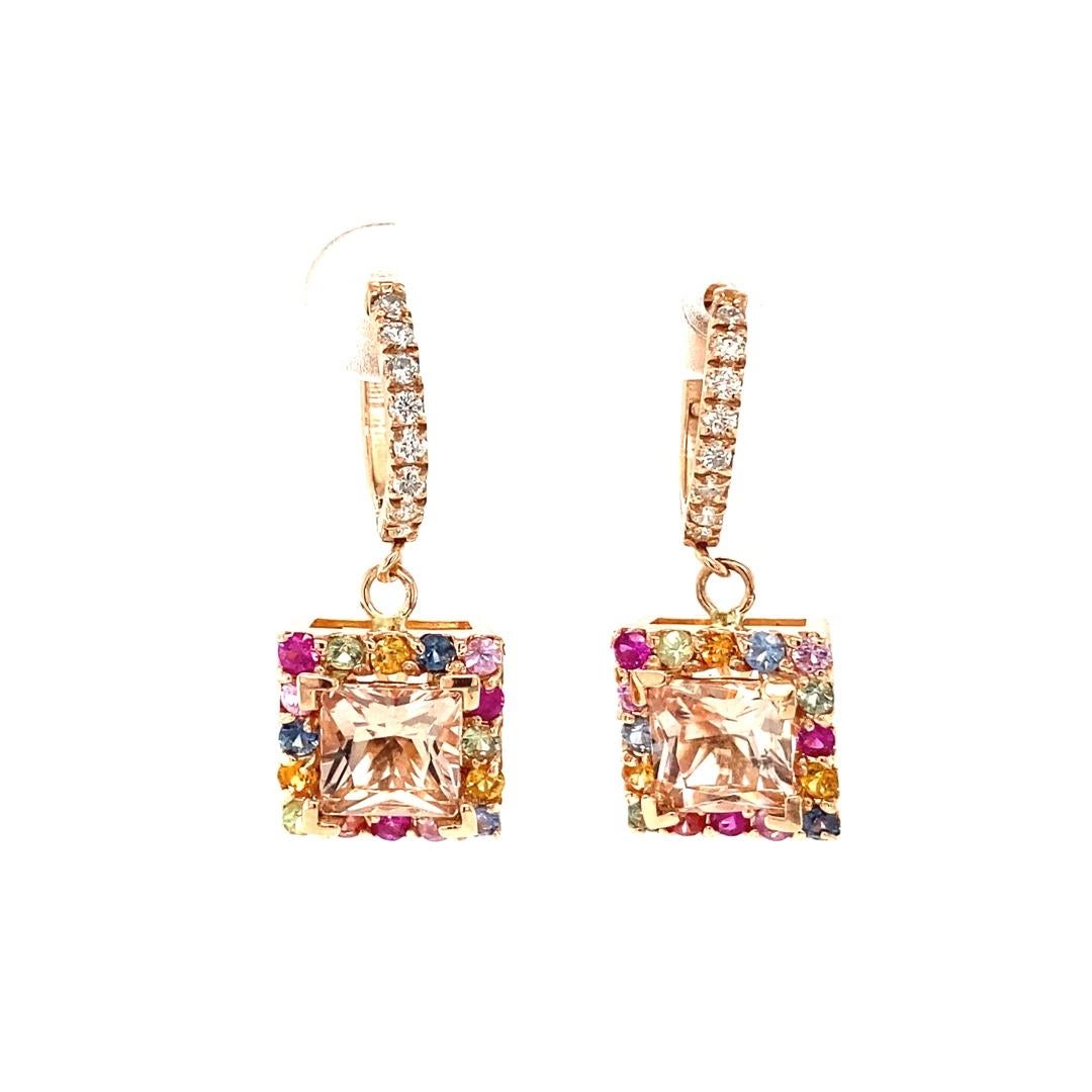 These beautiful earrings have Square Cut Pink Morganites that weigh 3.11 carats, Round Cut Multi Color Sapphires that weigh 1.18 carats and Round Cut Diamonds that weigh 0.27 carats. The Total Carat Weight of the Earrings is 4.56 carats. 
The