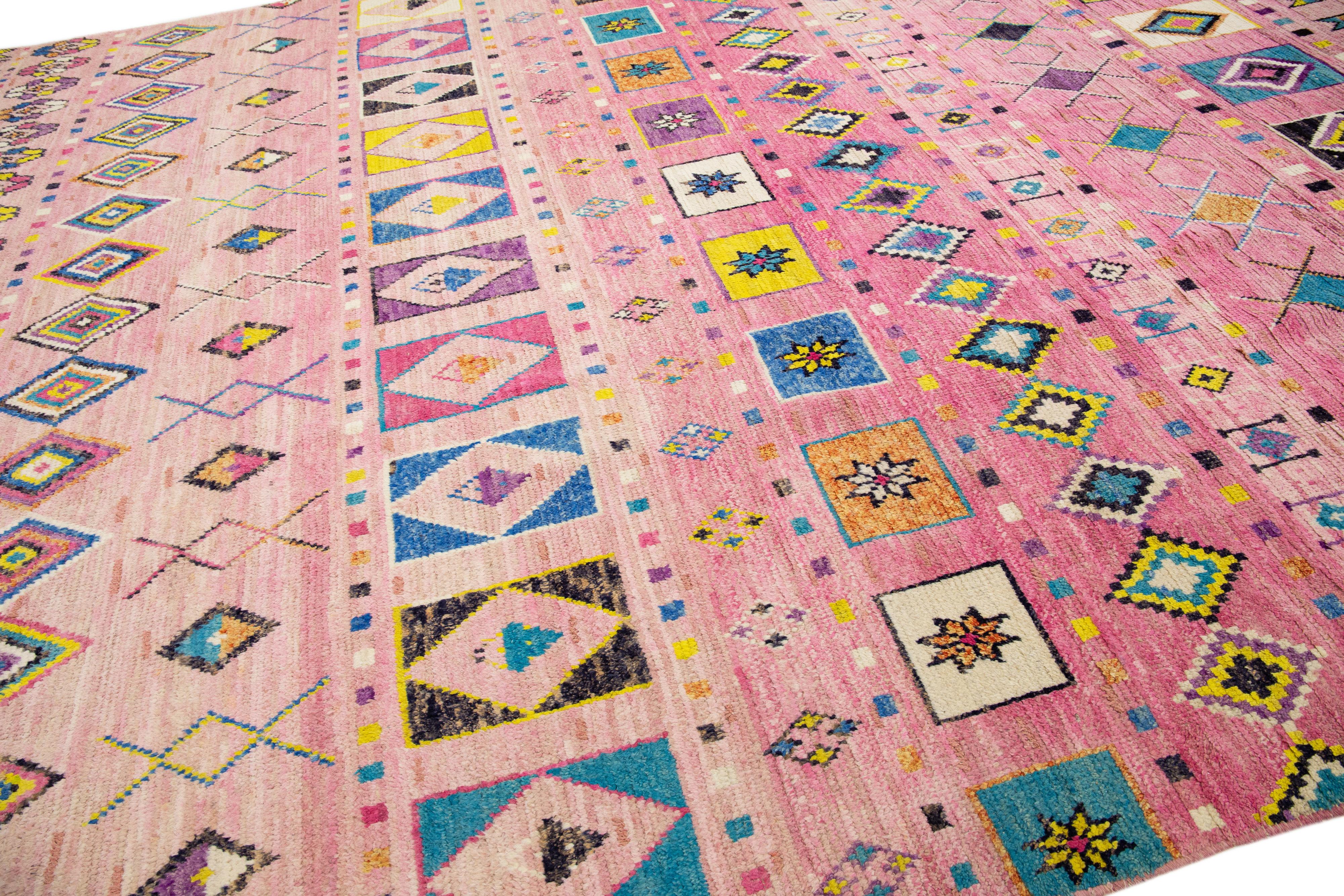 Beautiful moroccan berber style hand-knotted wool rug with a pink field. This piece has multicolor accents in an all-over geometric design.

This rug measures: 12' x 15'6