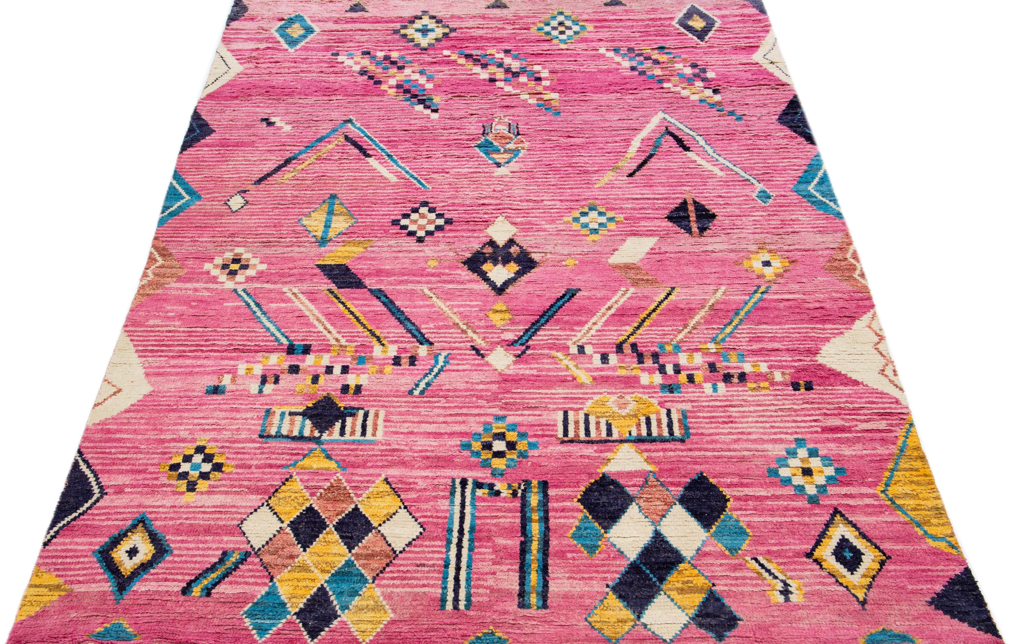 Bellissimo tappeto in lana annodato a mano in stile berbero marocchino con campo rosa. Questo pezzo presenta accenti multicolore in un disegno tribale geometrico all-over.

Questo tappeto misura: 8' x 12'5
