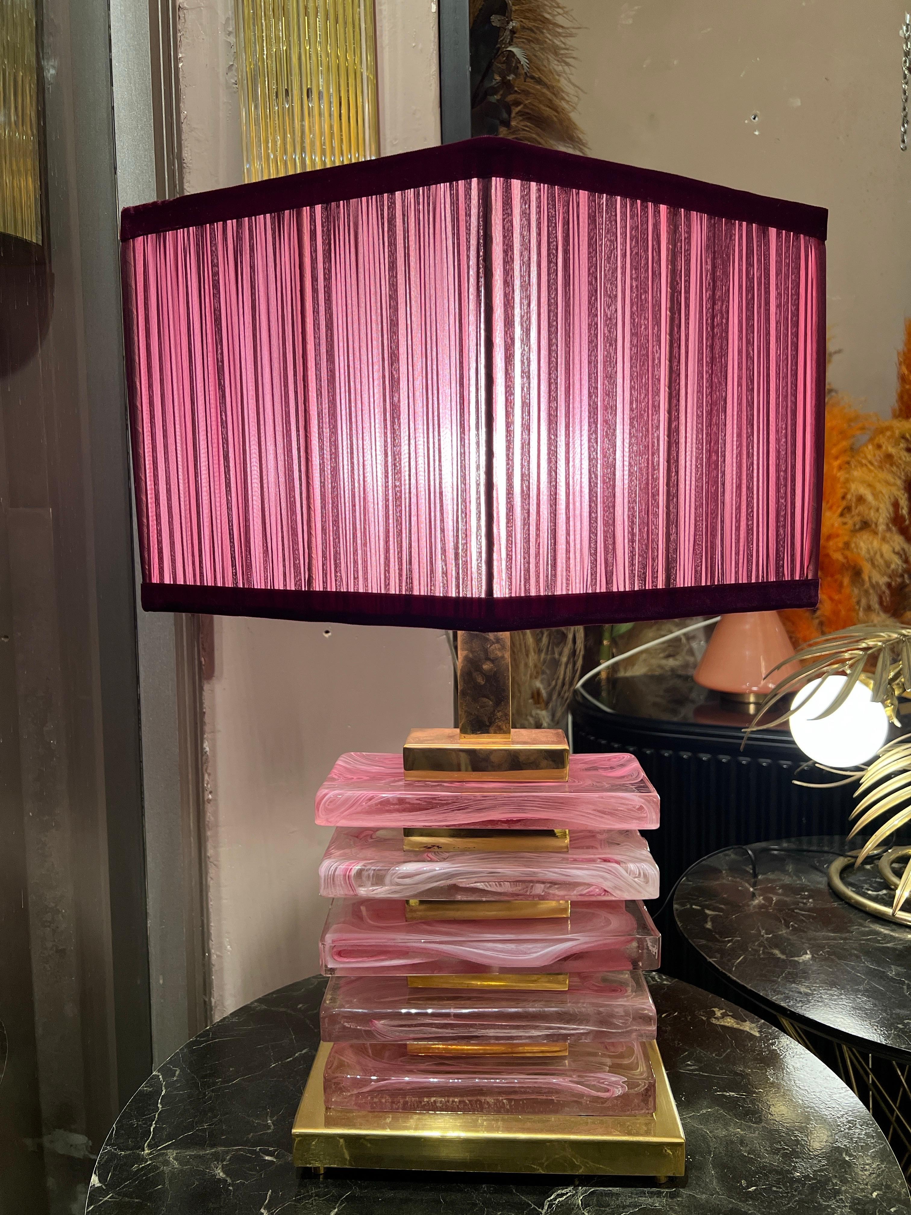 Lámpara de sobremesa de bloques de cristal de Murano rosa con herrajes de latón y nuestra pantalla romboidal a juego.
Los bloques rosas de cristal de Murano están soplados a mano con cristal de Murano transparente, creando un efecto mixto. Los