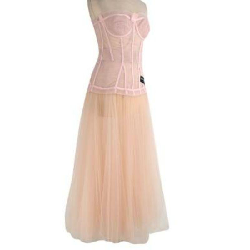 Dolce & Gabbana Pink & Nude Tulle Bustier Dress
 
 - Light pink sheer bustier top half with structured boning and gold tone zip fastening at the back 
 - Branded logo patch along the left side near the hip 
 - Mid length, layered tulle skirt in