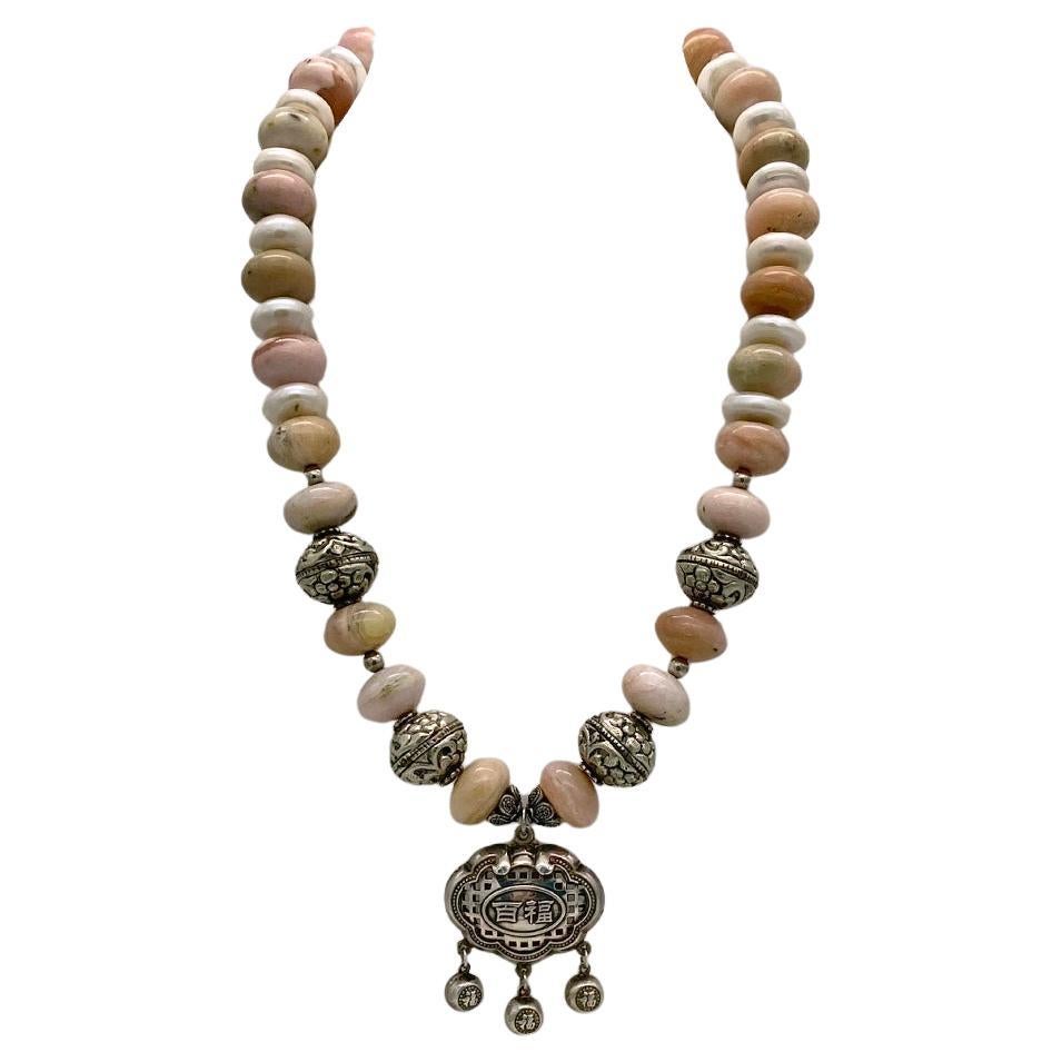 This is an opal, pearl and fine silver necklace. We created this necklace with 15-17mm opaque pink opals, 14mm button pearls and oxidized Bali sterling components plus a 999 fine silver dangling 