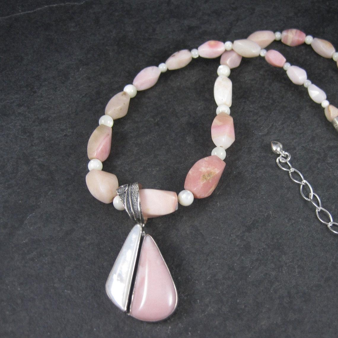 This gorgeous ensemble features a graduated pink opal and mother of pearl necklace with a complimenting sterling silver, mother of pearl and pink opal pendant.

The necklace features beads graduated from 5 to 10mm and sterling silver components.
It
