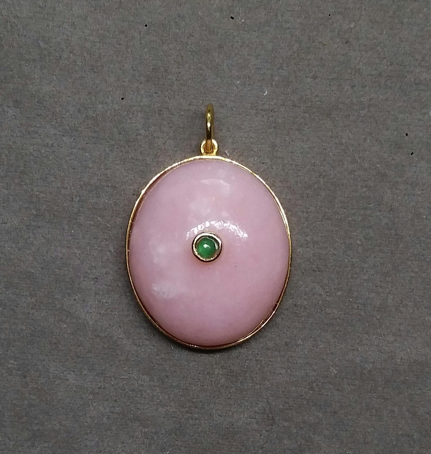 Pendentif simple et chic en Opale rose de forme ovale mesurant 19mm x 22 mm serti dans un chaton en or jaune 14 Kt. et avec une Emeraude Cab de forme ronde.  au centre, serti dans une lunette en or jaune 14k
En 1978, notre atelier a démarré en