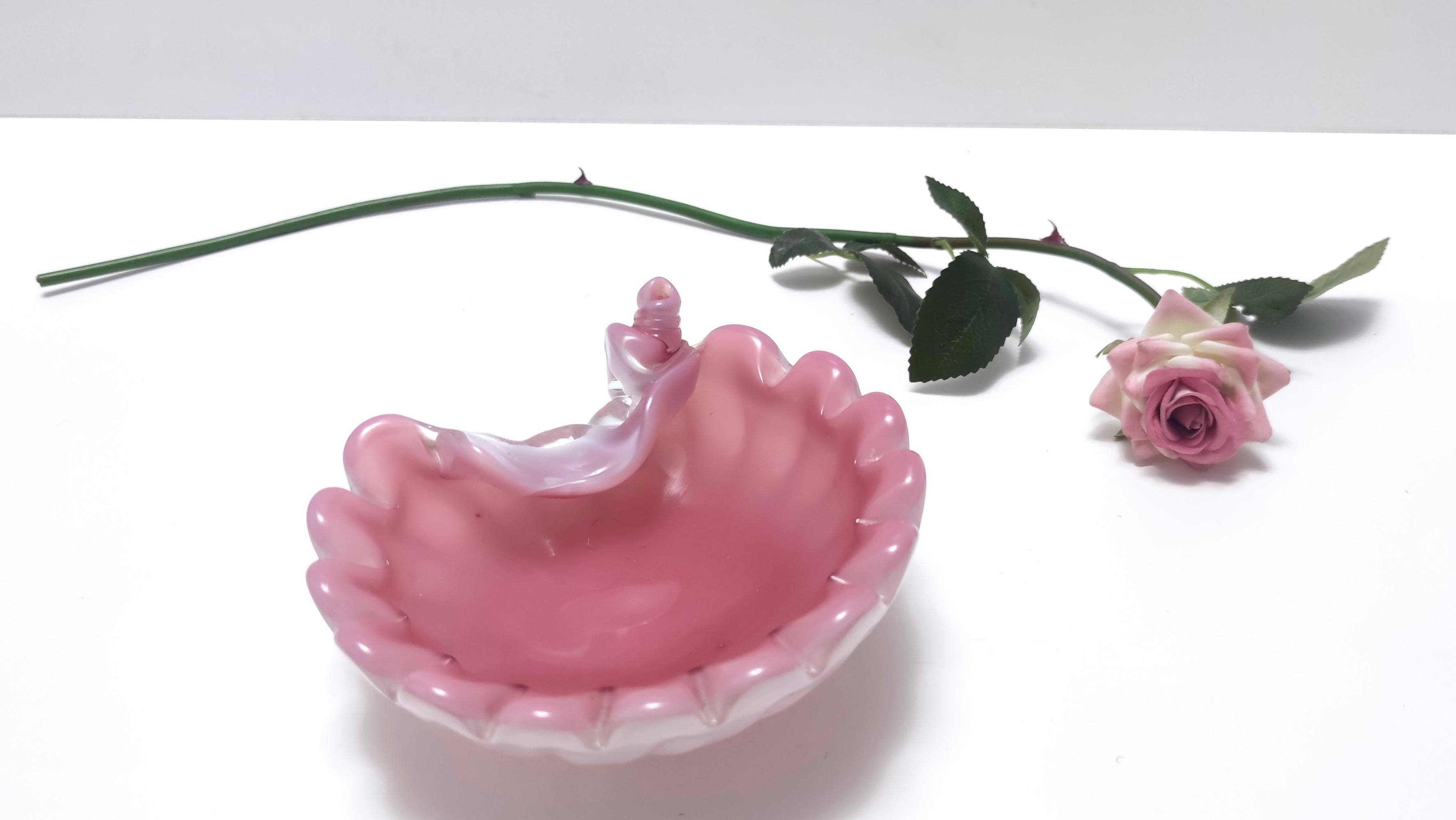 Opalescent shell bowl / ashtray by Fratelli Toso, Italy, circa 1959.
This shell bowl / ashtray is made in pink hand-blown opaline glass under 'lattimo' glass opalescent ribs, with a scalloped rim and folded ends.
In perfect original condition and