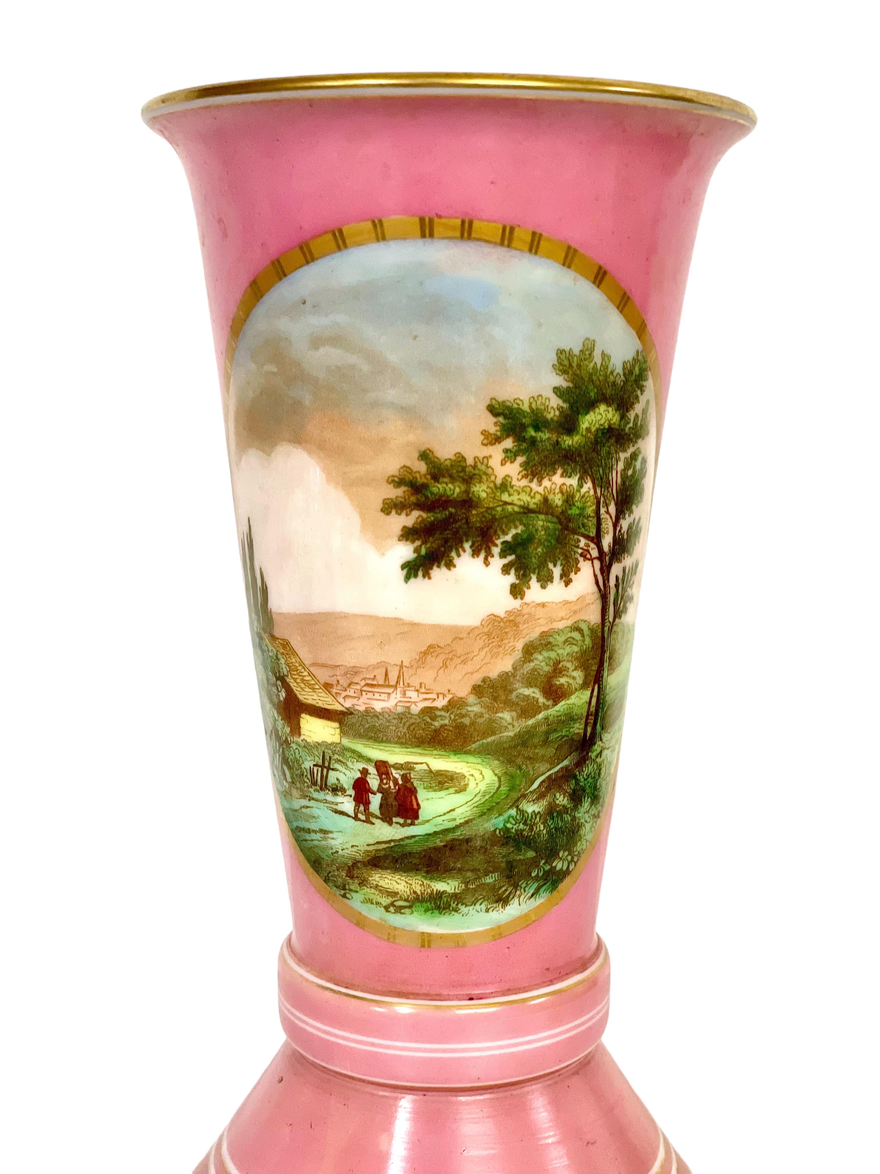 A very pretty pink opaline Sèvres-style vase, hand-blown and embellished throughout with gilt bands and accents. The tall and gently flaring neck has been beautifully hand-painted with a pastoral scene of figures in a rural landscape, its warm