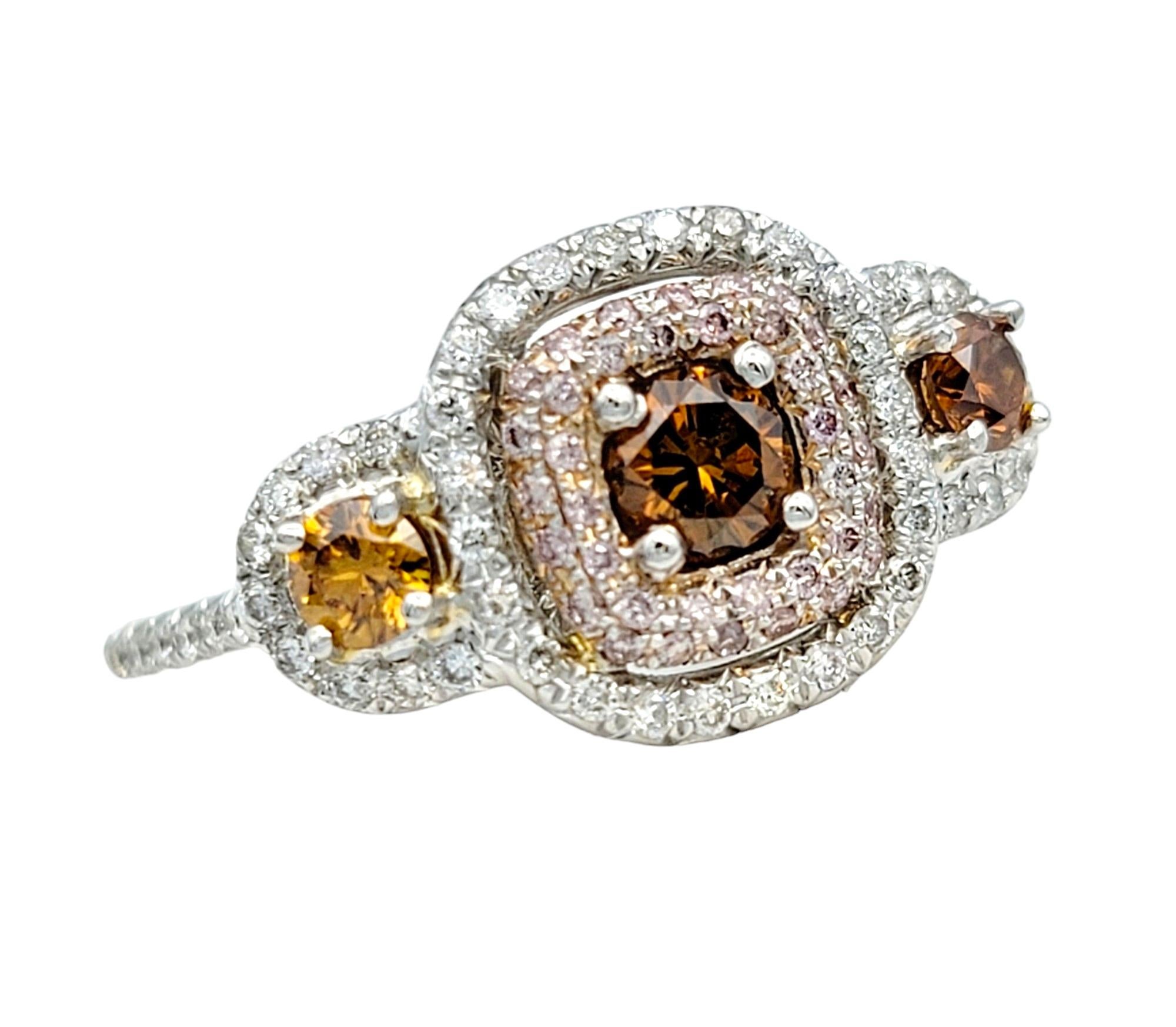 Ring Size: 7

This gorgeous three-stone style ring, crafted in luxurious 18 karat white gold, is a mesmerizing display of color and elegance. At its heart, brownish-orange diamonds stand out with radiant allure, each encircled by a squared halo of
