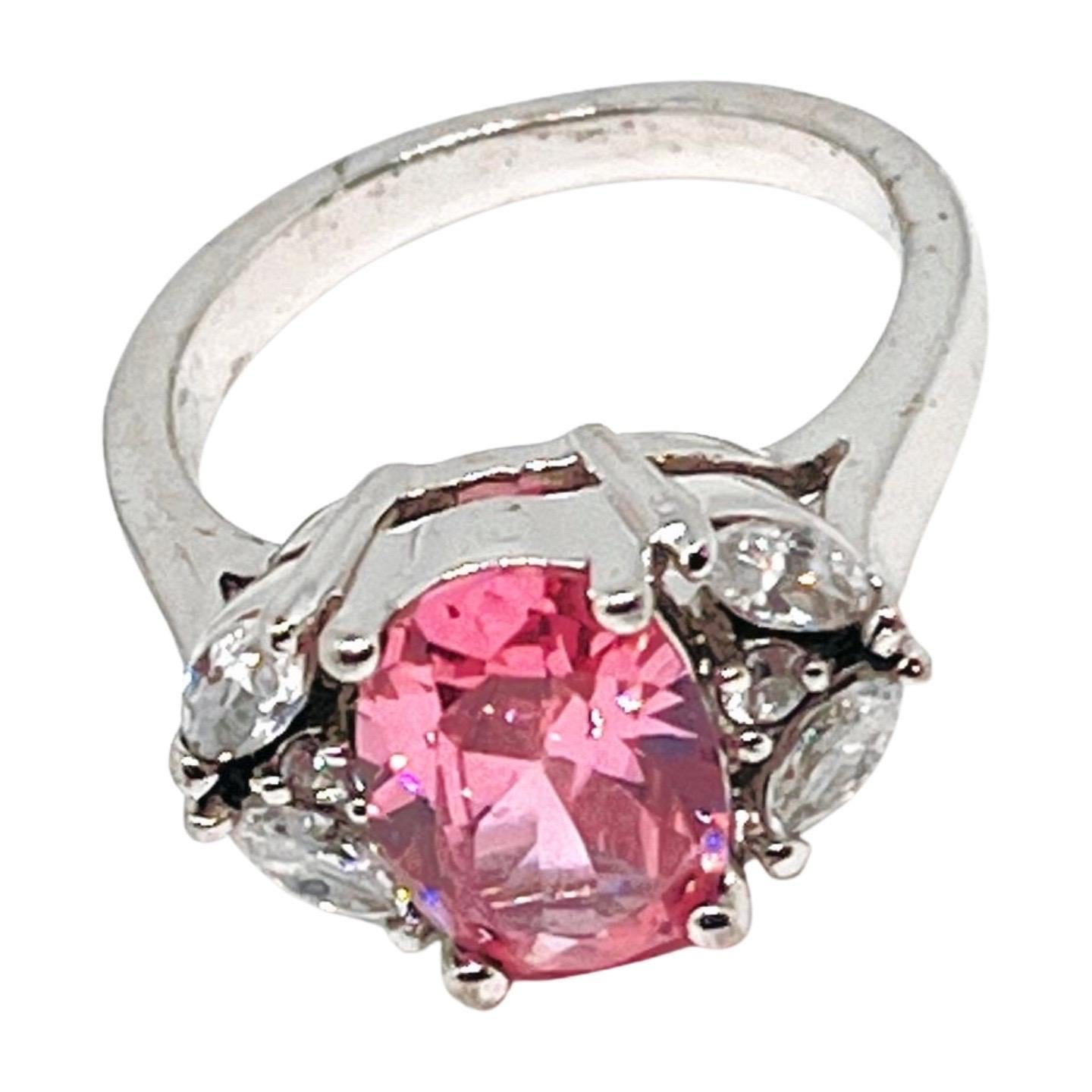 Blush-pink oval cut cubic zirconia crystal ring set in a silver-toned band, framed by six shimmering clear accents for an elegant (four marquise cut), vintage-inspired silhouette. A timeless symbol of romance and grace, perfect for heartfelt gifting