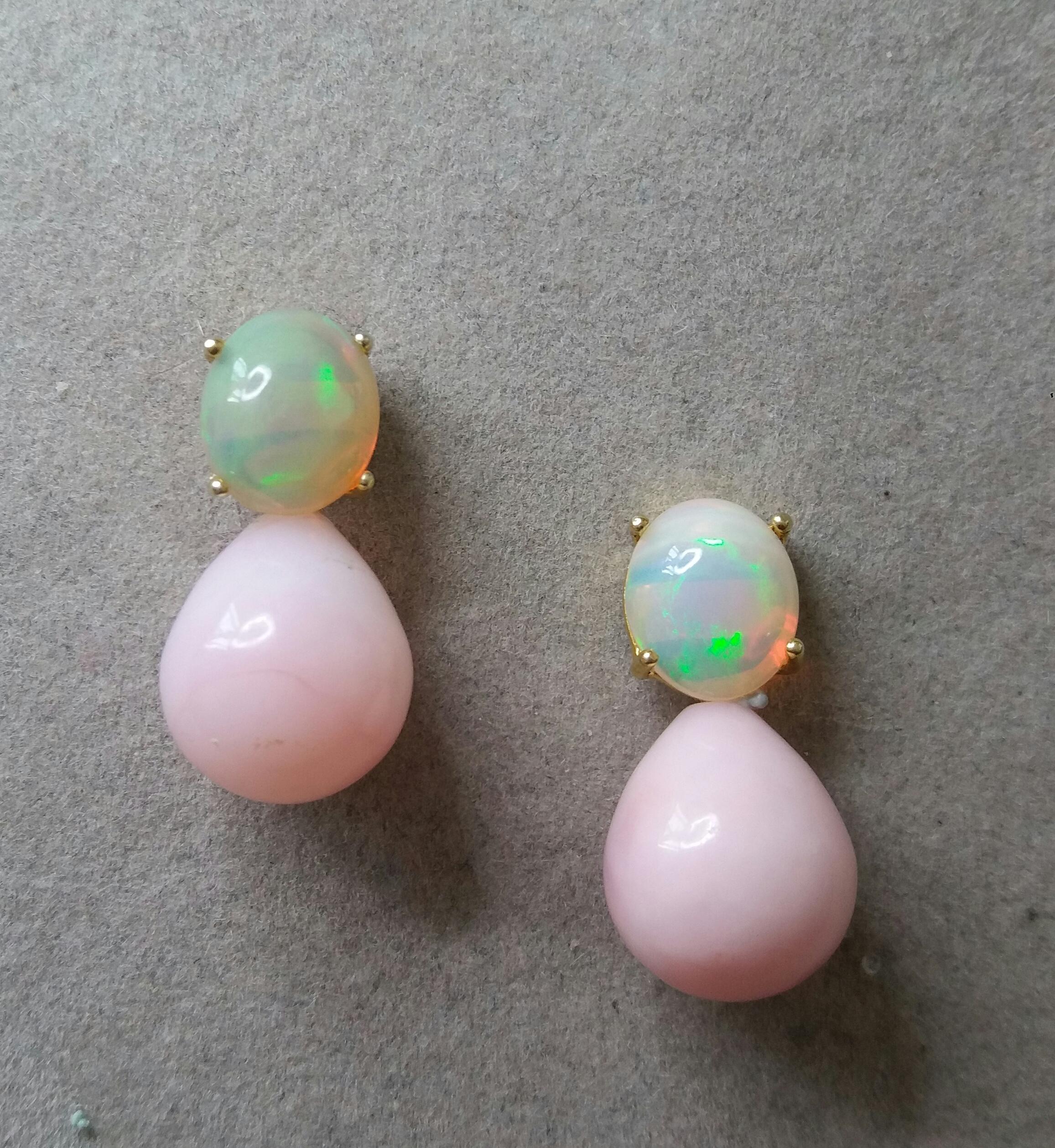These simple but elegant earrings have 2 Solid Opal Oval Cabs 10mm x 11 mm set in yellow gold at the top to which are suspended 2 Pink Opal Plain Round Drops measuring 13mm x 15 mm.

In 1978 our workshop started in Italy to make simple-chic Art Deco