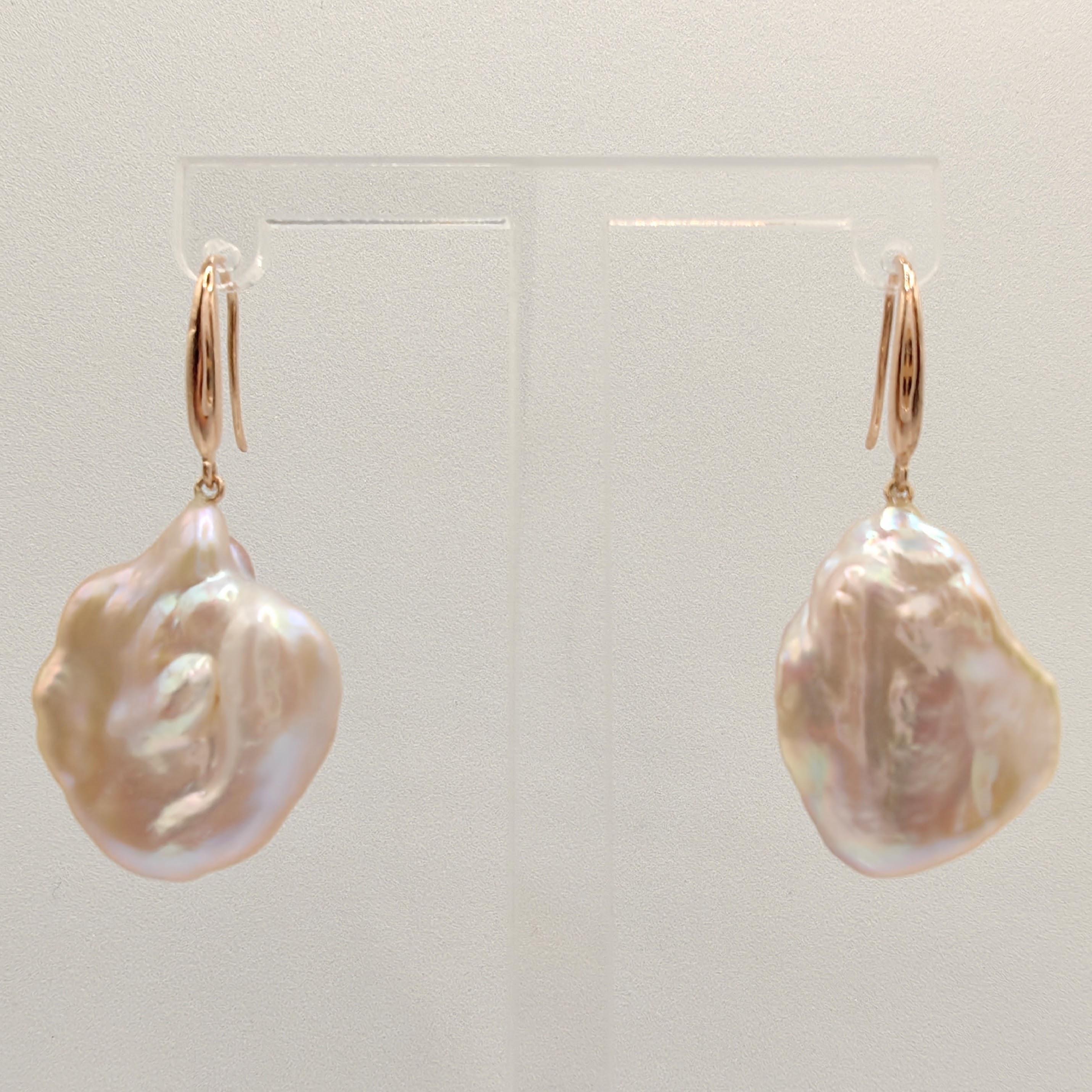 Rehaussez votre look avec le charme éthéré de nos boucles d'oreilles pendantes en perles Keshi rose-pêche, une célébration de l'élégance délicate et de la beauté naturelle. Ces boucles d'oreilles exquises sont composées de perles de culture d'eau