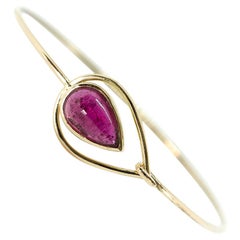 A Bangle Bracelet in 18 Yellow Gold Set with a Pink Tourmaline Cabochon